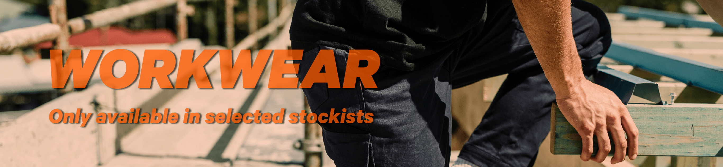 Tradie in Jetpilot workwear work pants kneeling on a timber frame at an Aussie building site