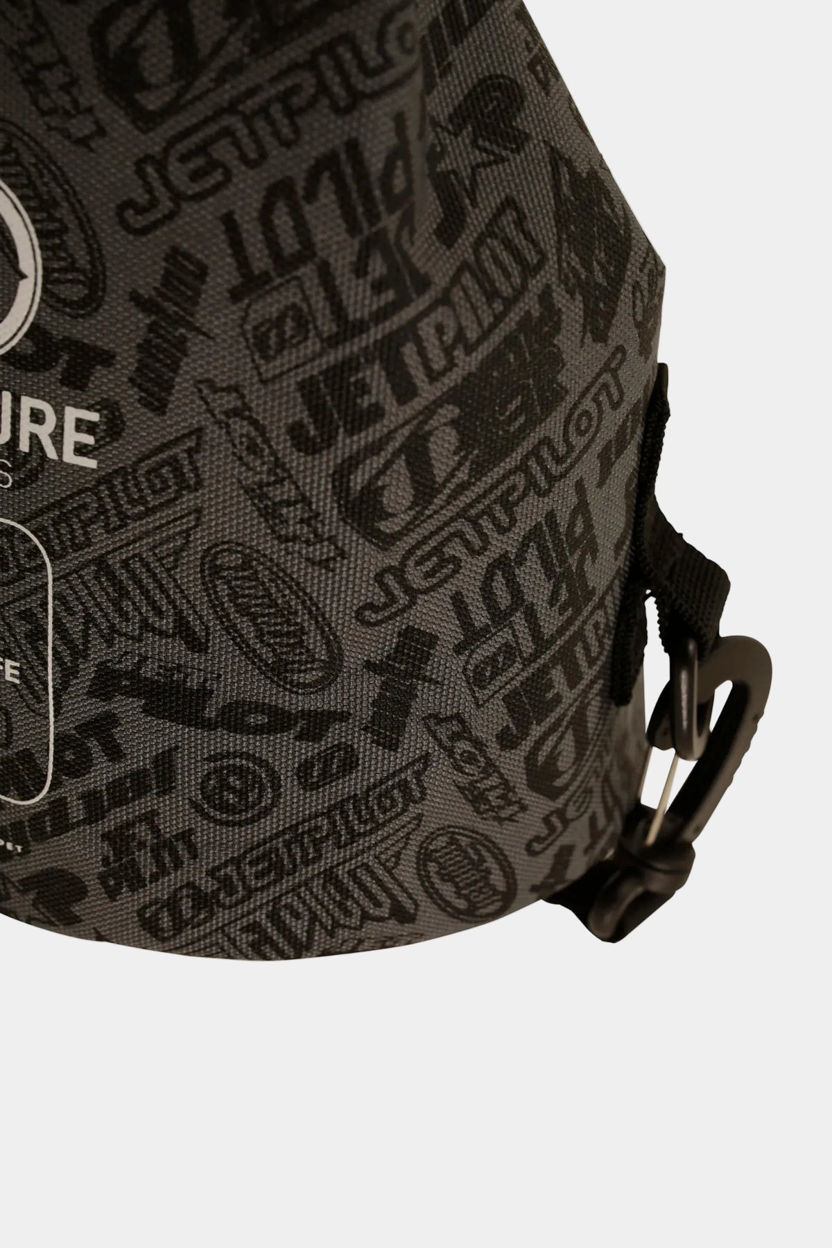 Close-up of the all-over Jetpilot logo print and side strap clip on the Black 40 Year 5L