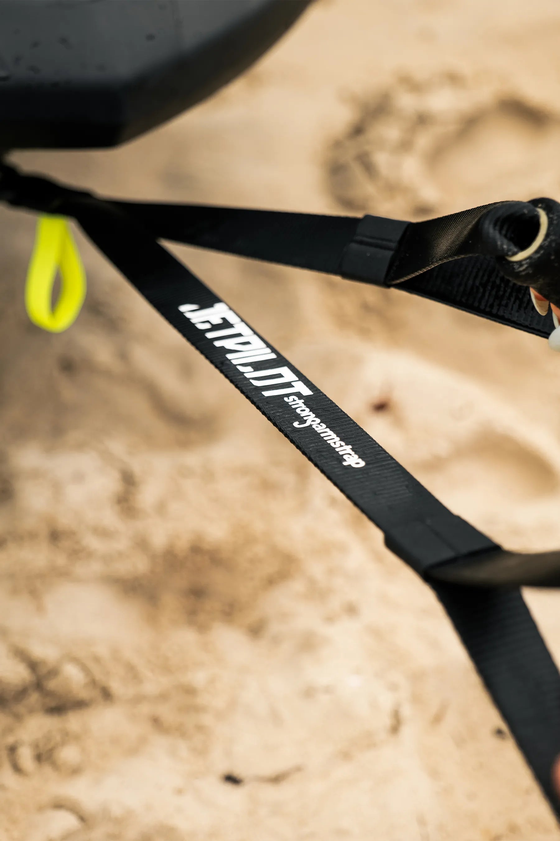 Black strap with 'Jetpilot' branding on a sandy background