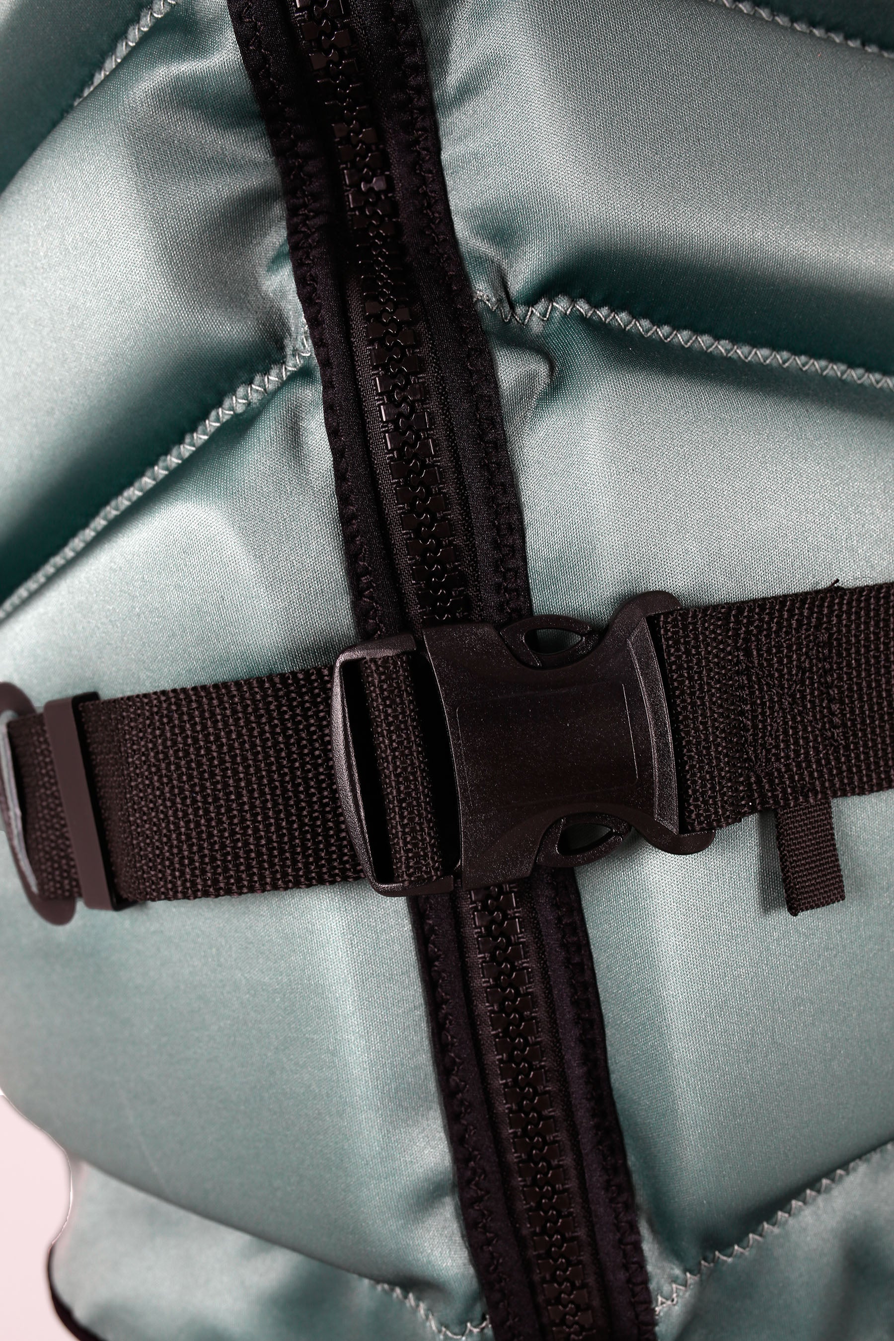 Close-up of a Jetpilot Freeride Life Jacket - Sage with black straps and zippers.