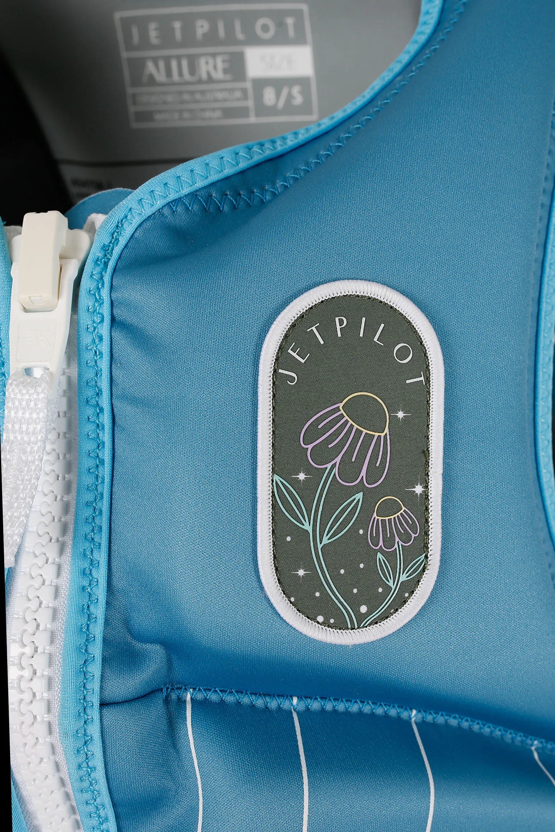Jetpilot Allure Ladies Life Jacket - Blue with oval grey and floral patch, with Jetpilot branding — image 2