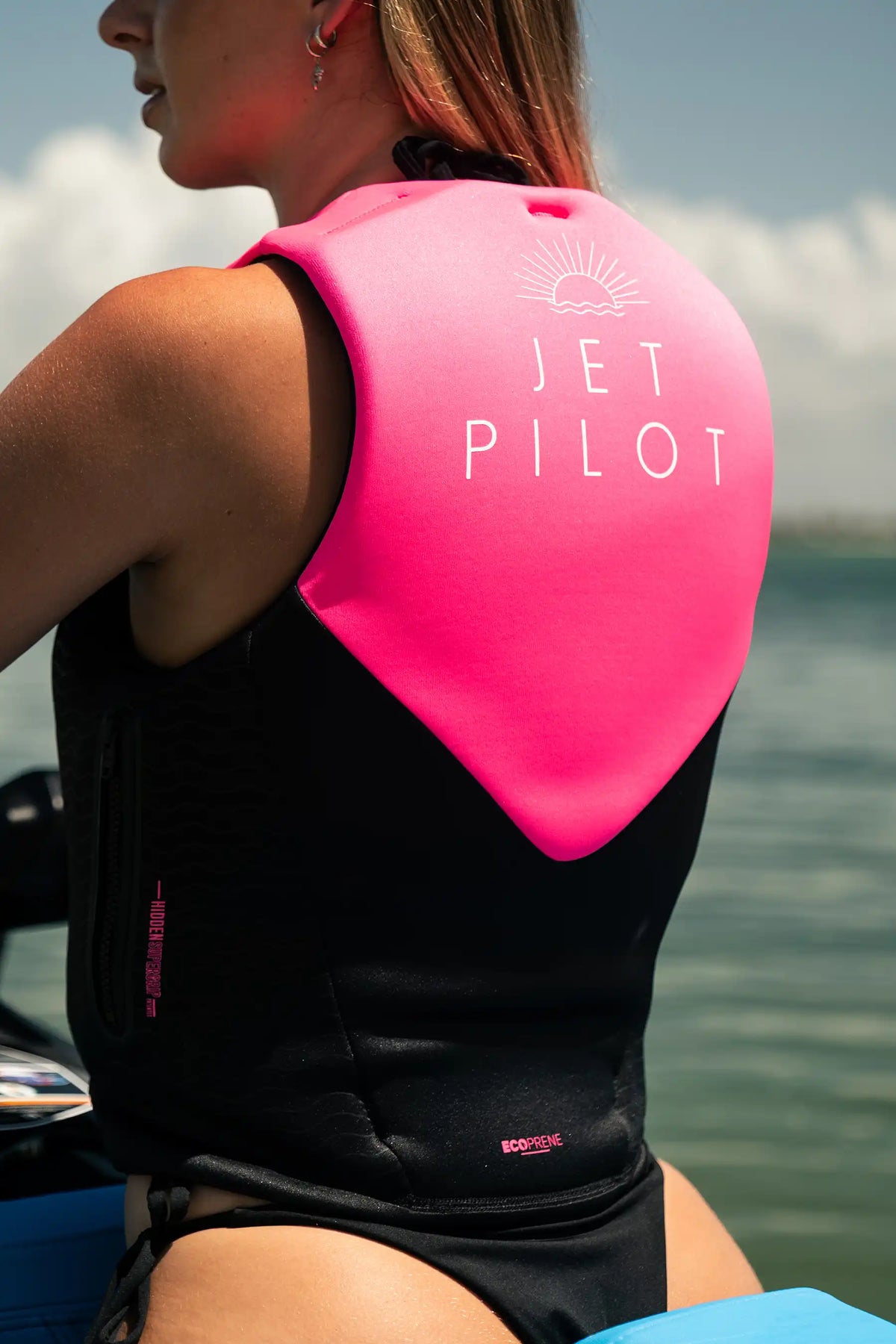 Rider on a jet ski seen from behind, showing the Jetpilot sunrise print on the Pink Cause Ladies