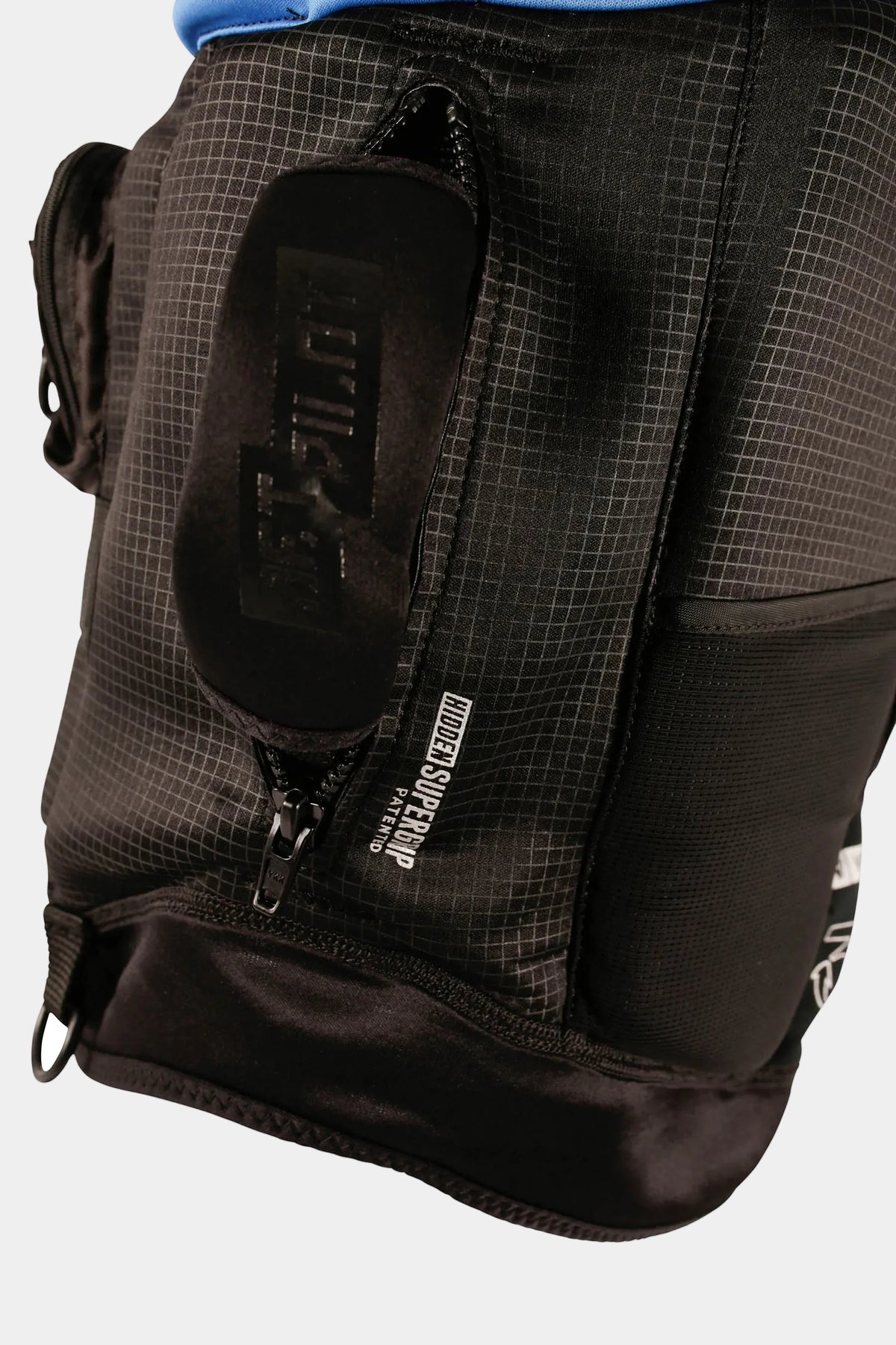 Close-up of a black technical outdoor life vest with a front zippered pocket, a black zippered side pocket, and a visible 'JBL' brand patch on a white background.