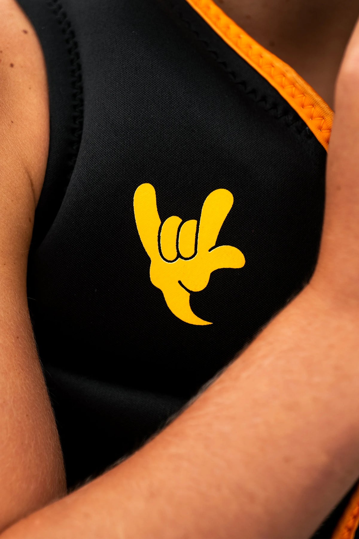 Close-up of the yellow shaka on the chest of the Black Freeride Boys, worn by a young rider