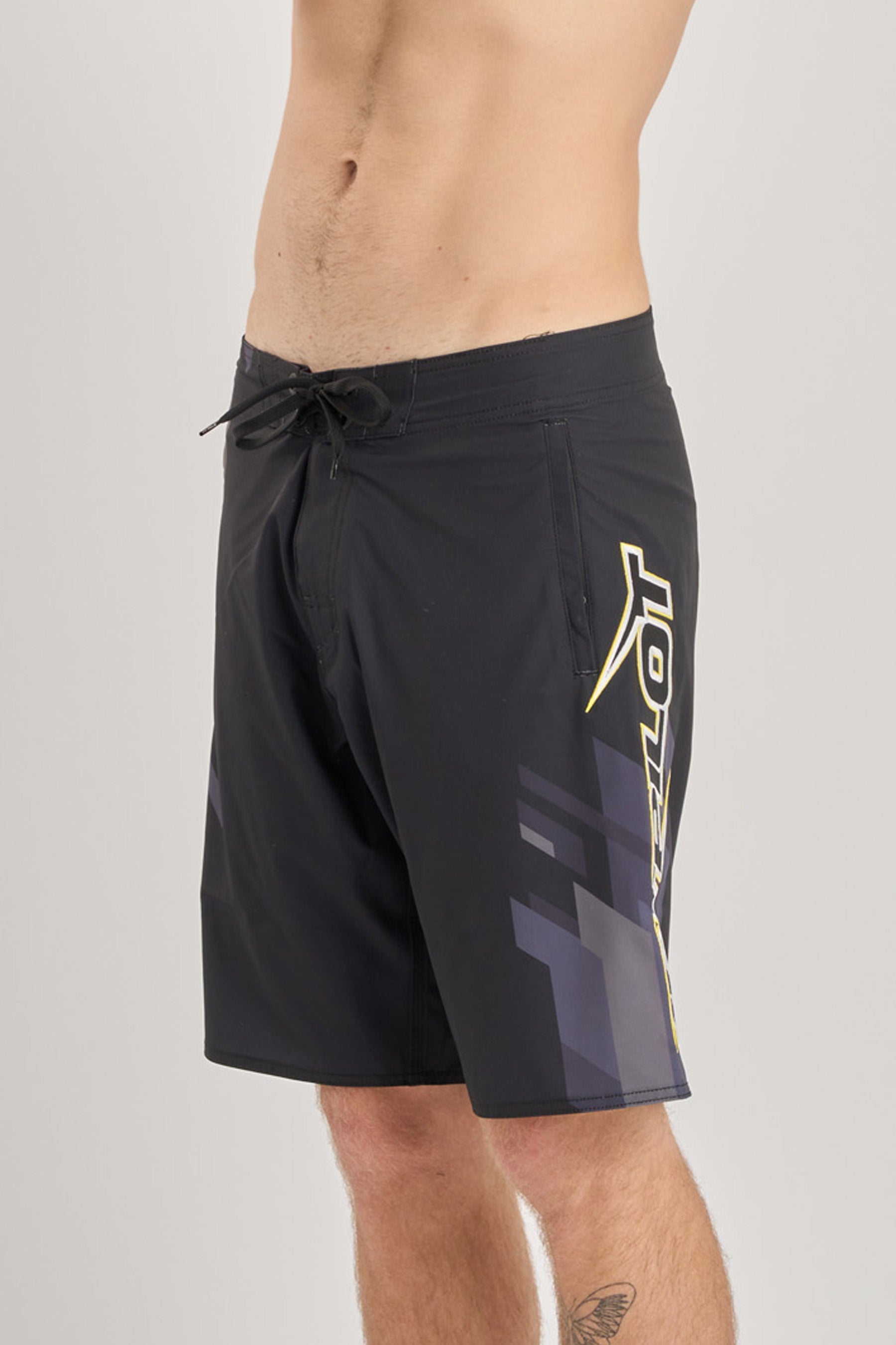 Black shorts with a yellow logo on a gray background
