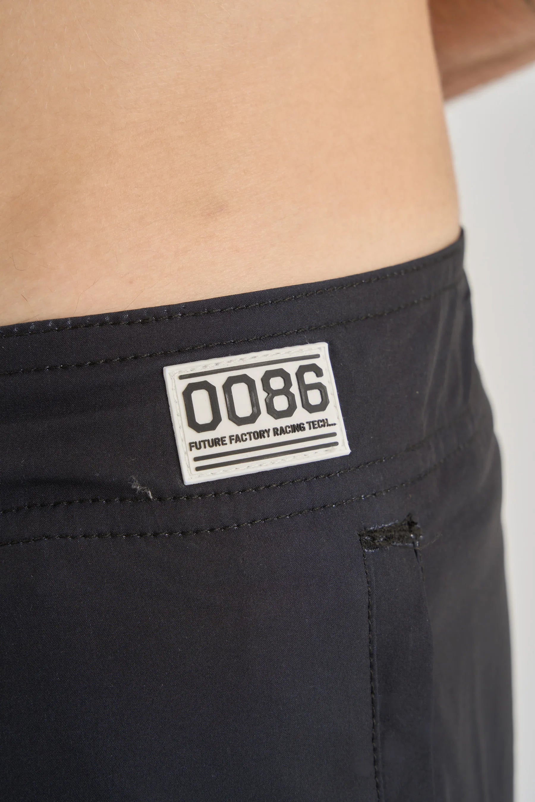 Black boardshorts with a visible label on a plain background
