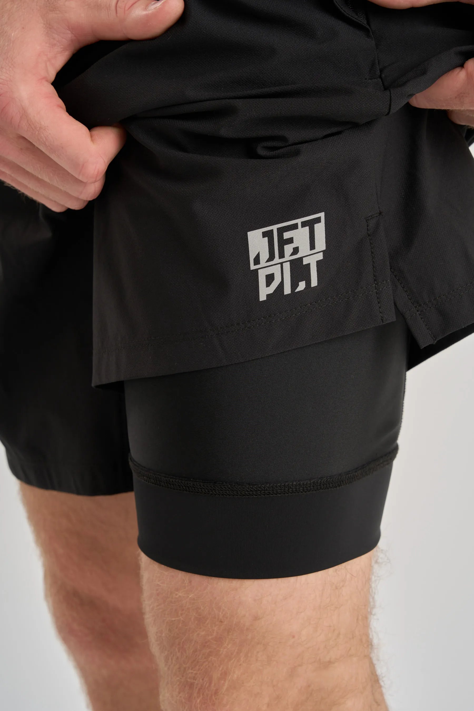 Black athletic shorts with a visible brand logo on a white background — image 2