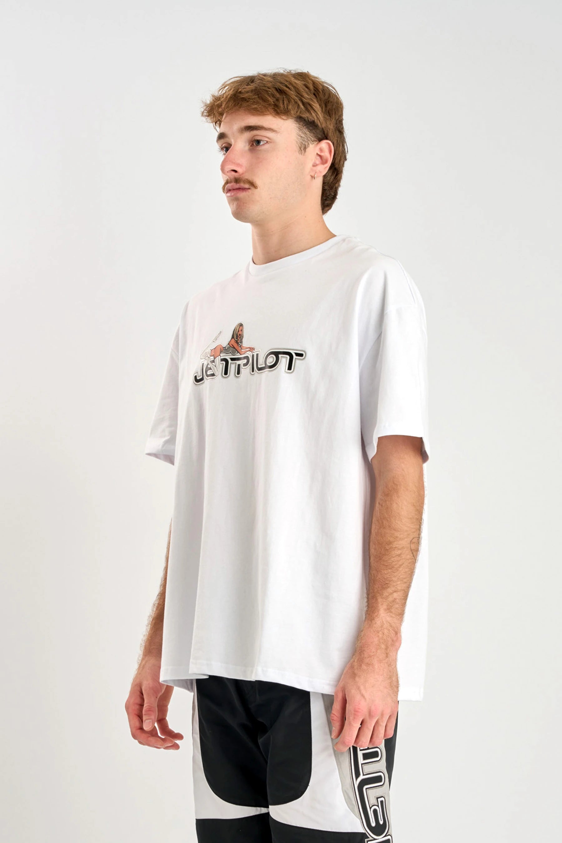 Person wearing a white t-shirt with a logo on a plain background