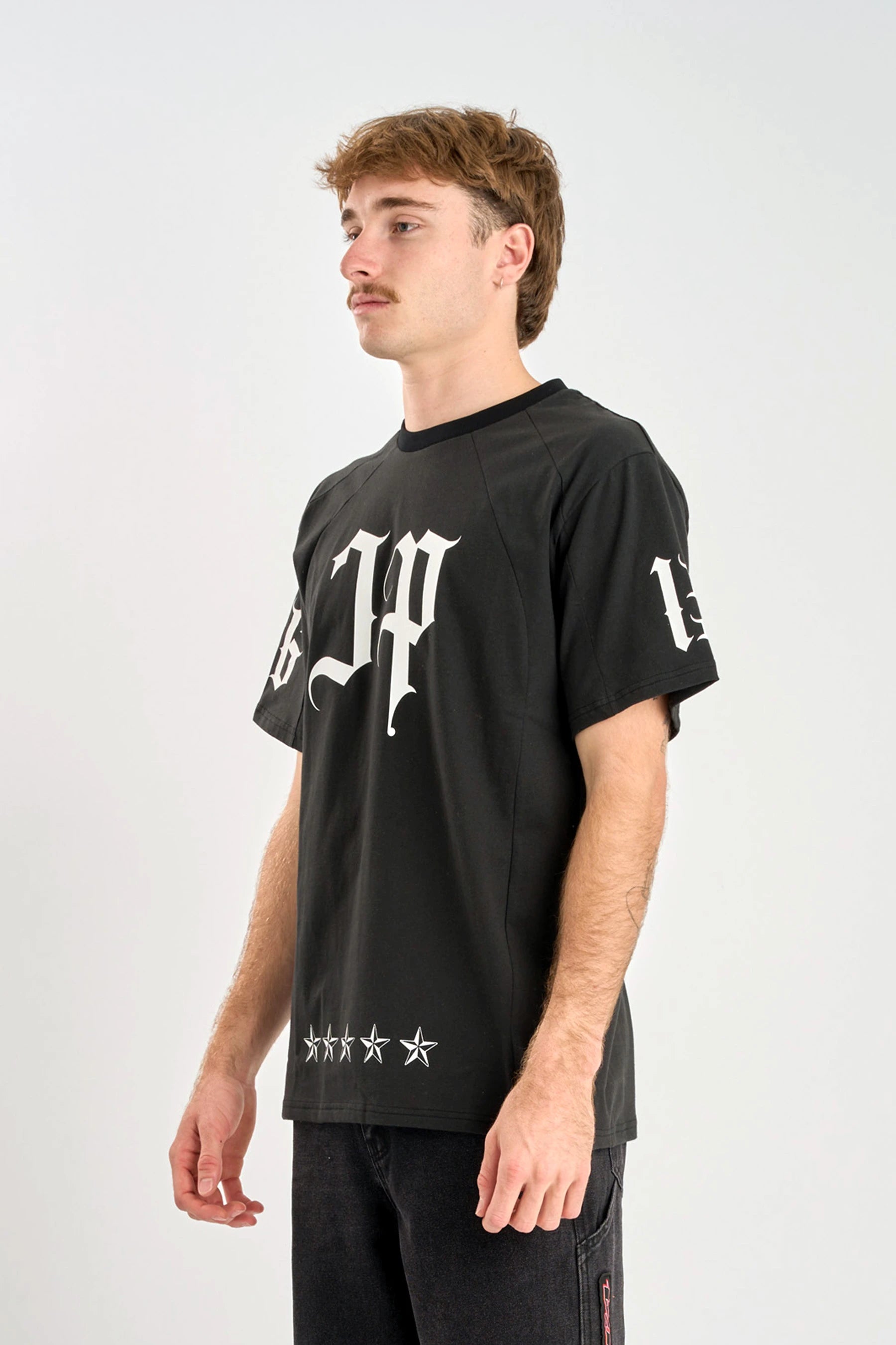 Person wearing a Jetpilot Battle Heavy Tee - Black with white graphics on a white background