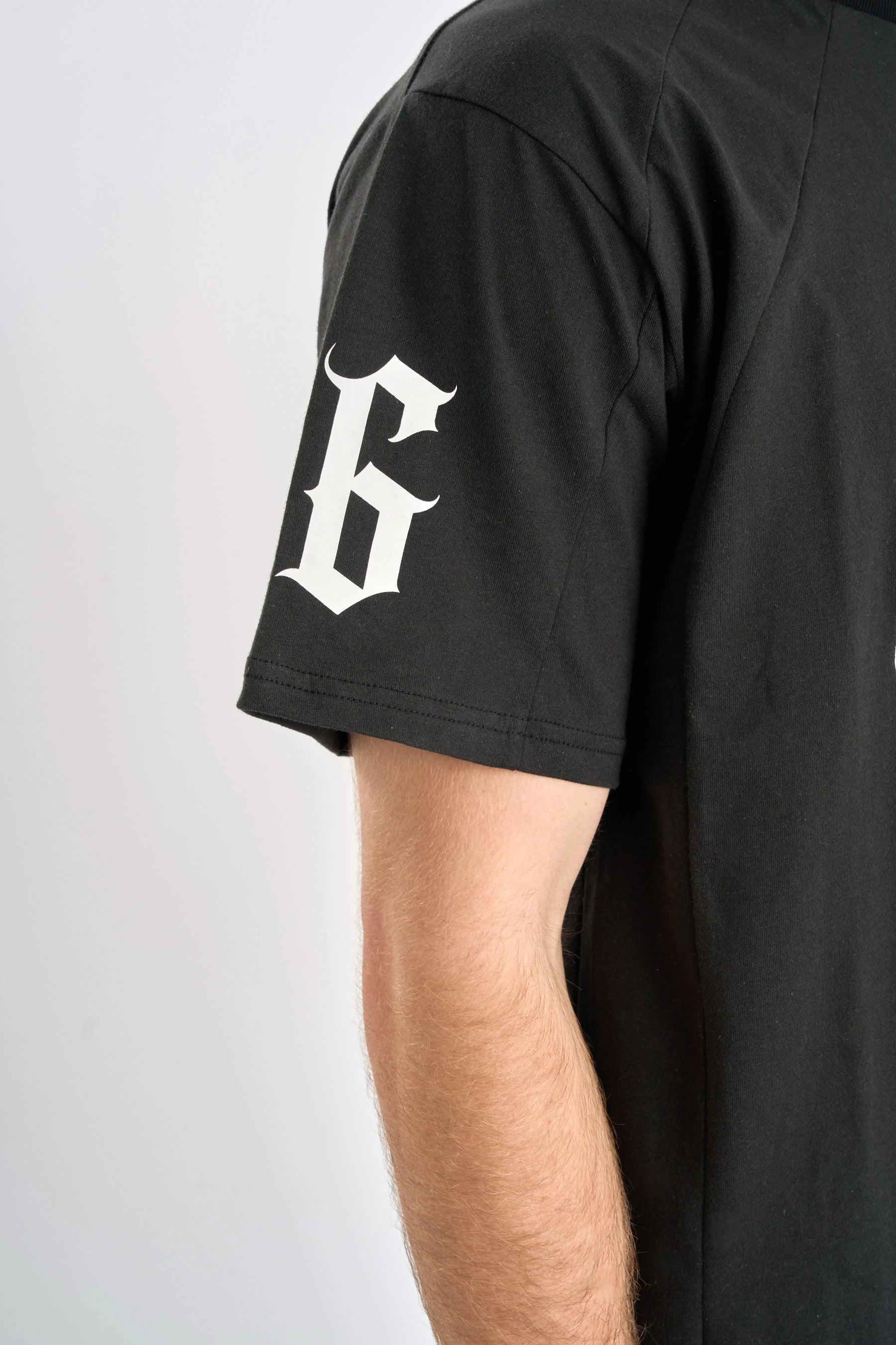 Black t-shirt with a large white number '86' on the sleeve against a light gray background