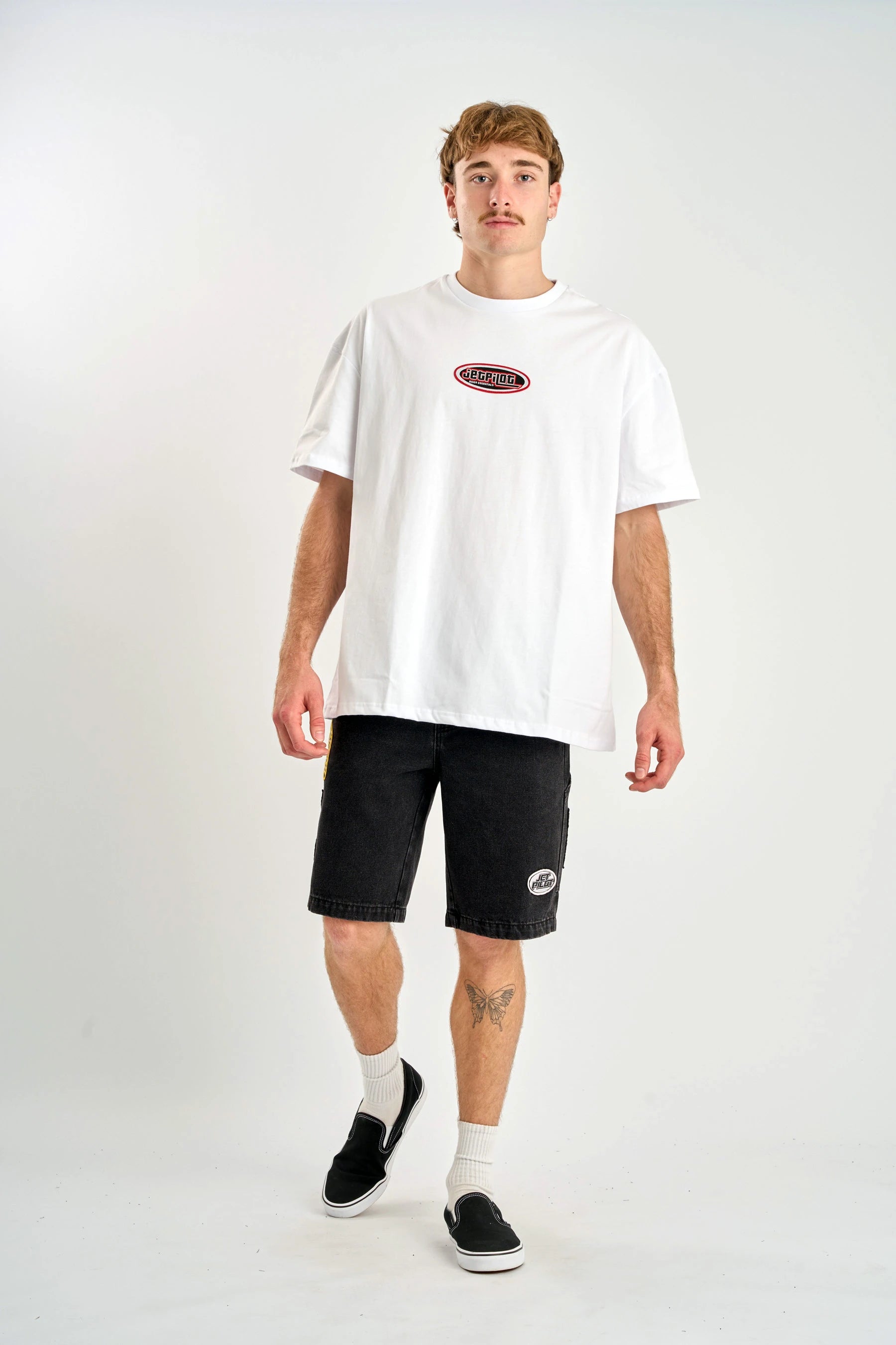 Man wearing a Jetpilot Factory Heavy Tee - White t-shirt and black shorts with logos on a white background — image 2
