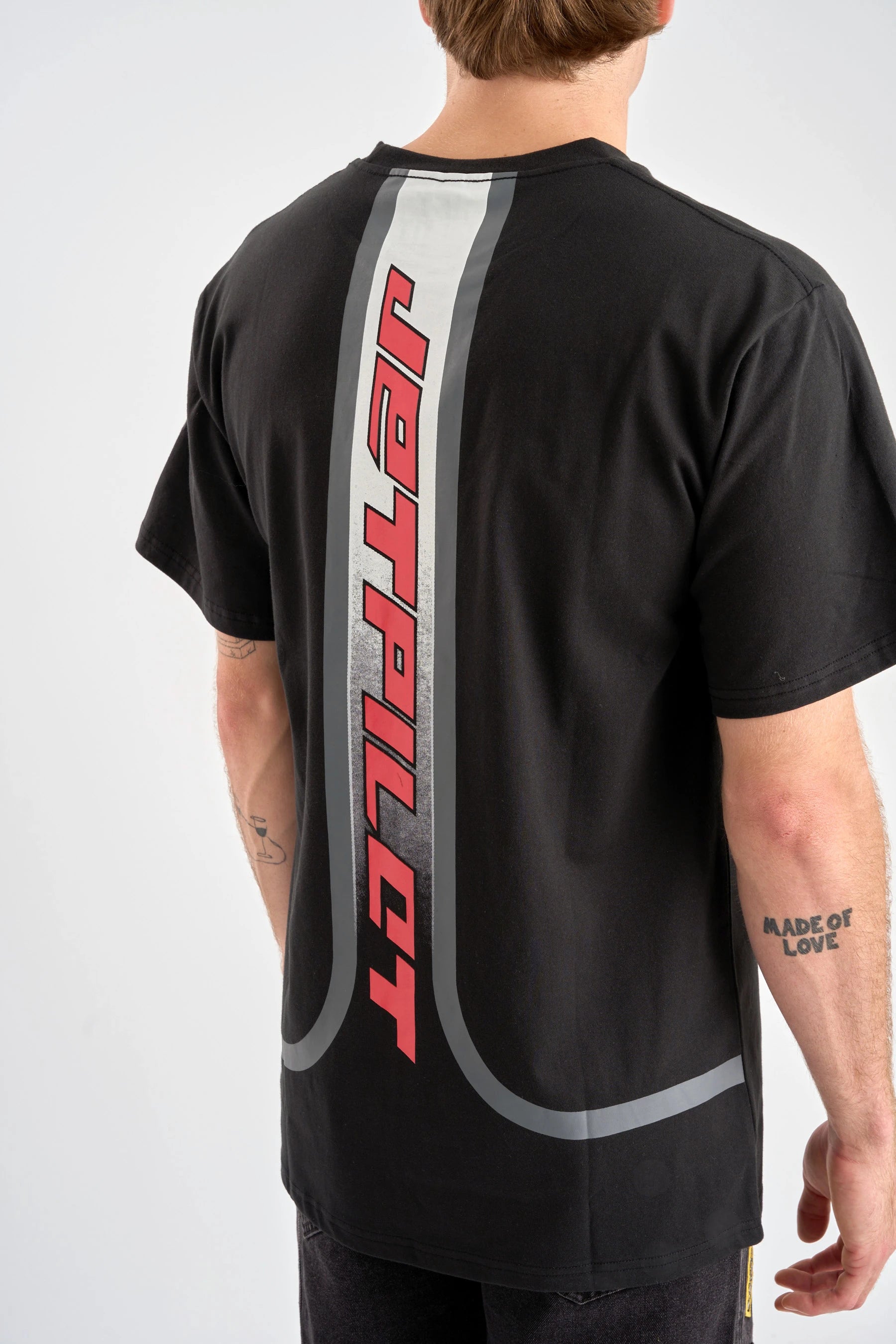 Person wearing a black t-shirt with red 'JETPILOT' branding on the back against a white background — image 2