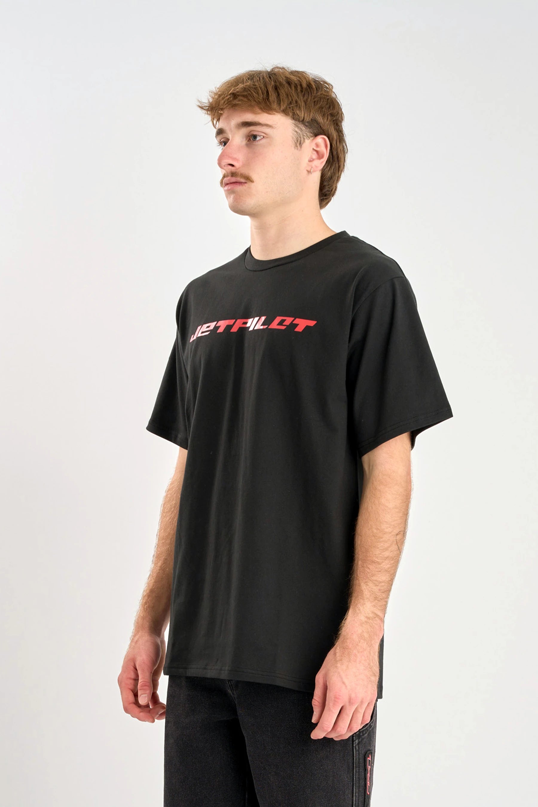 Person wearing a black t-shirt with red text on a white background — image 2