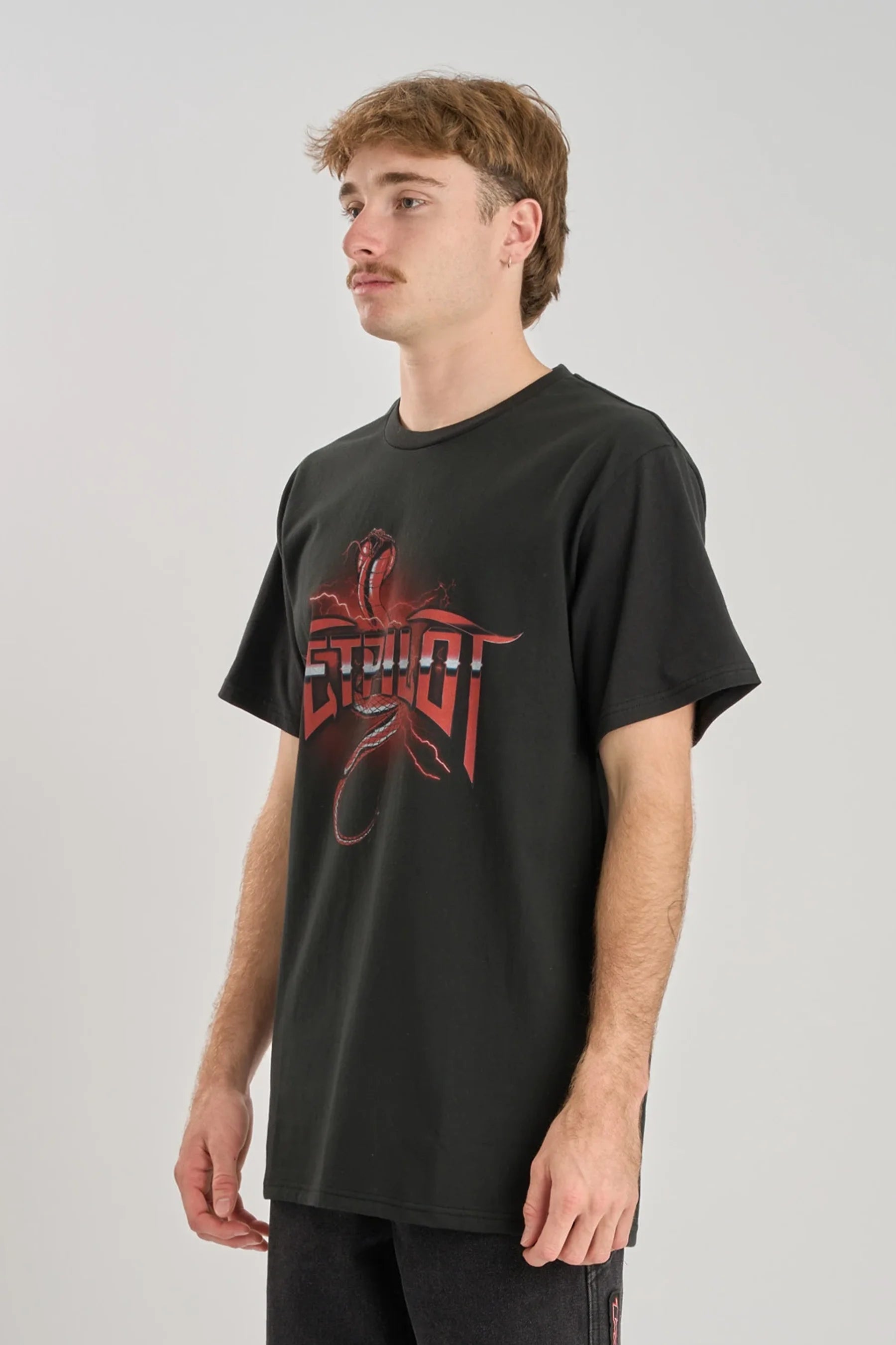 Person wearing a black t-shirt with red graphic design on a plain background — image 2