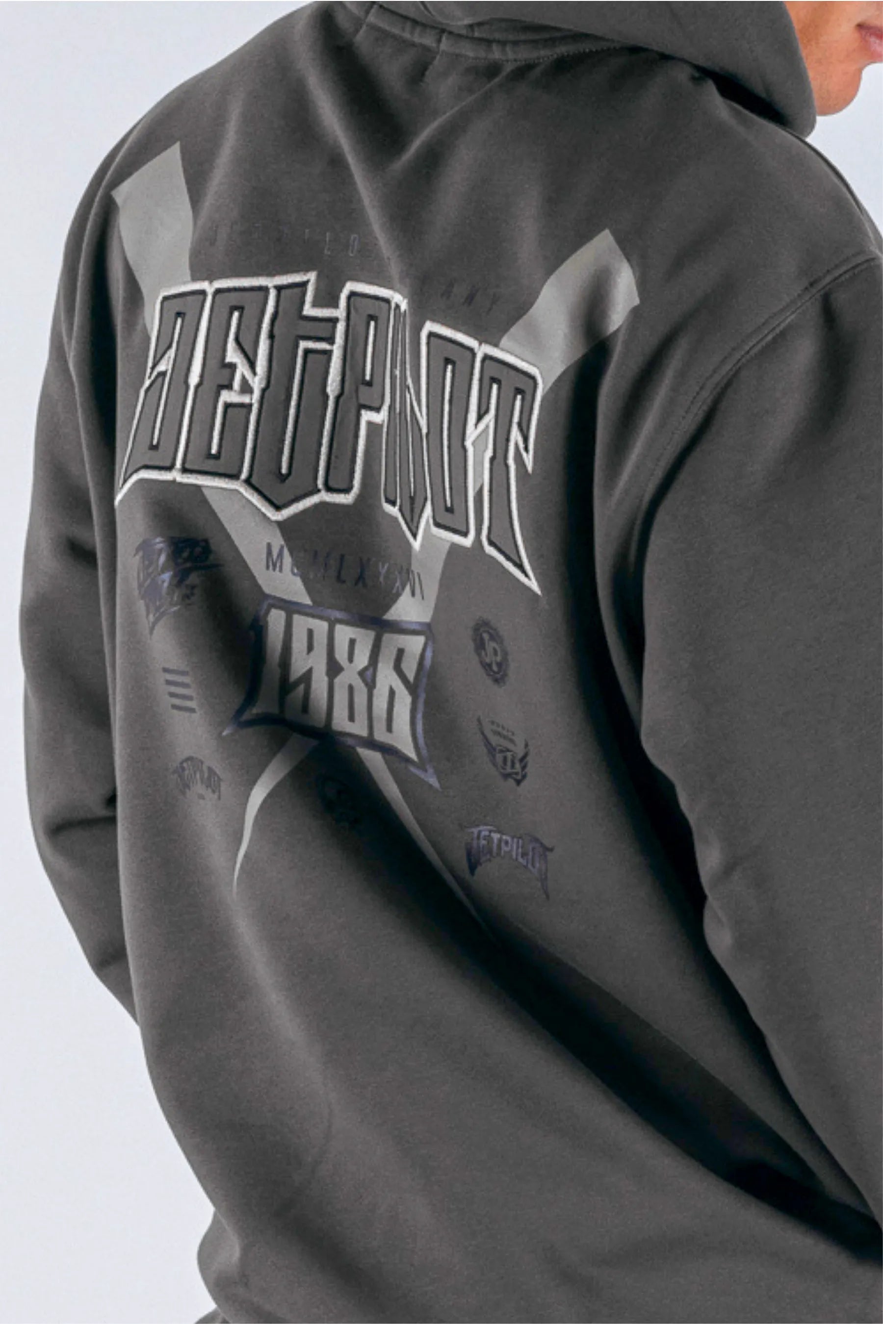 close up of the back view of a person wearing a black tee with a Jetpilot logo on a white background — view 5 (4)