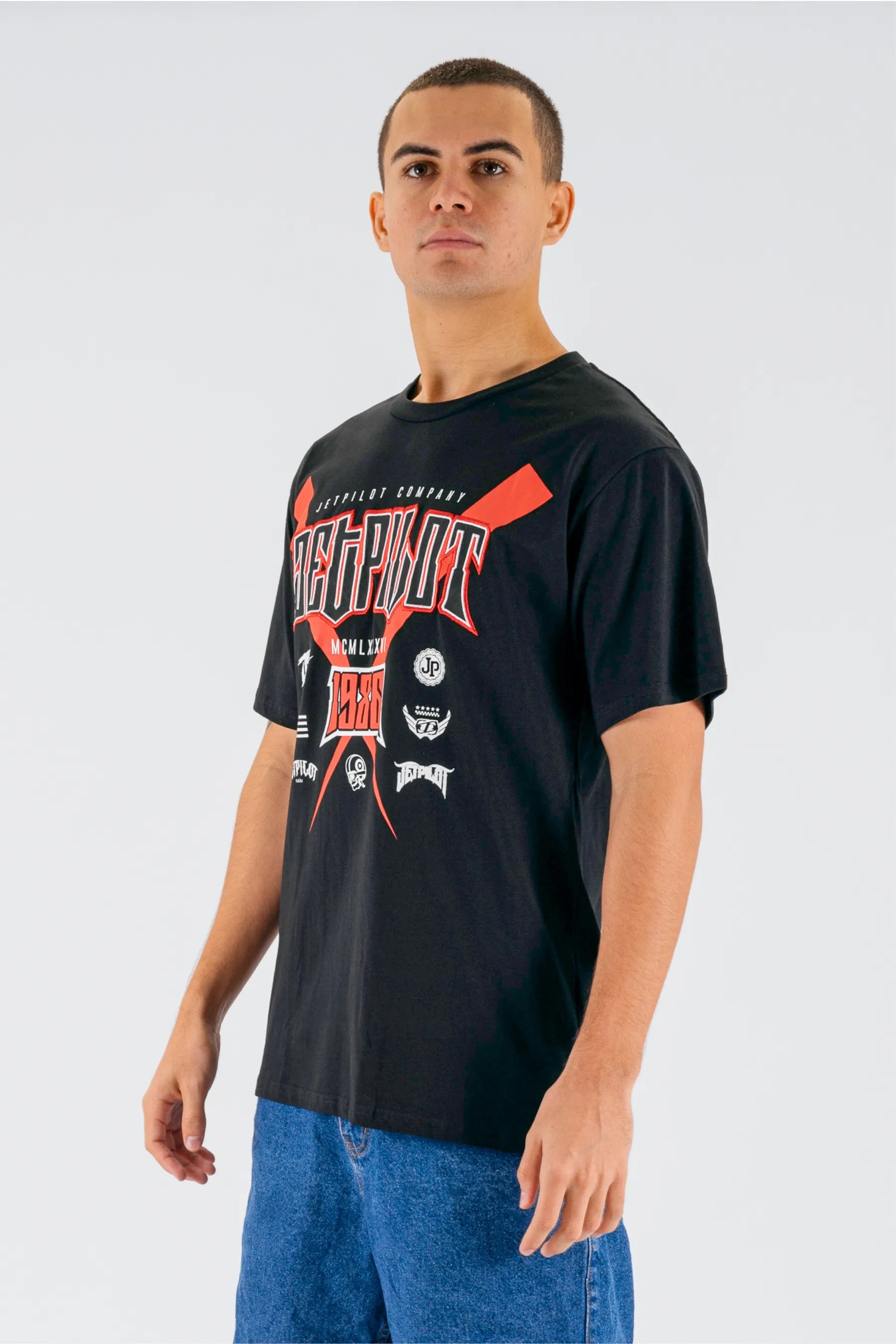 Person wearing a black t-shirt with graphic designs on a white background — view 3 (3)