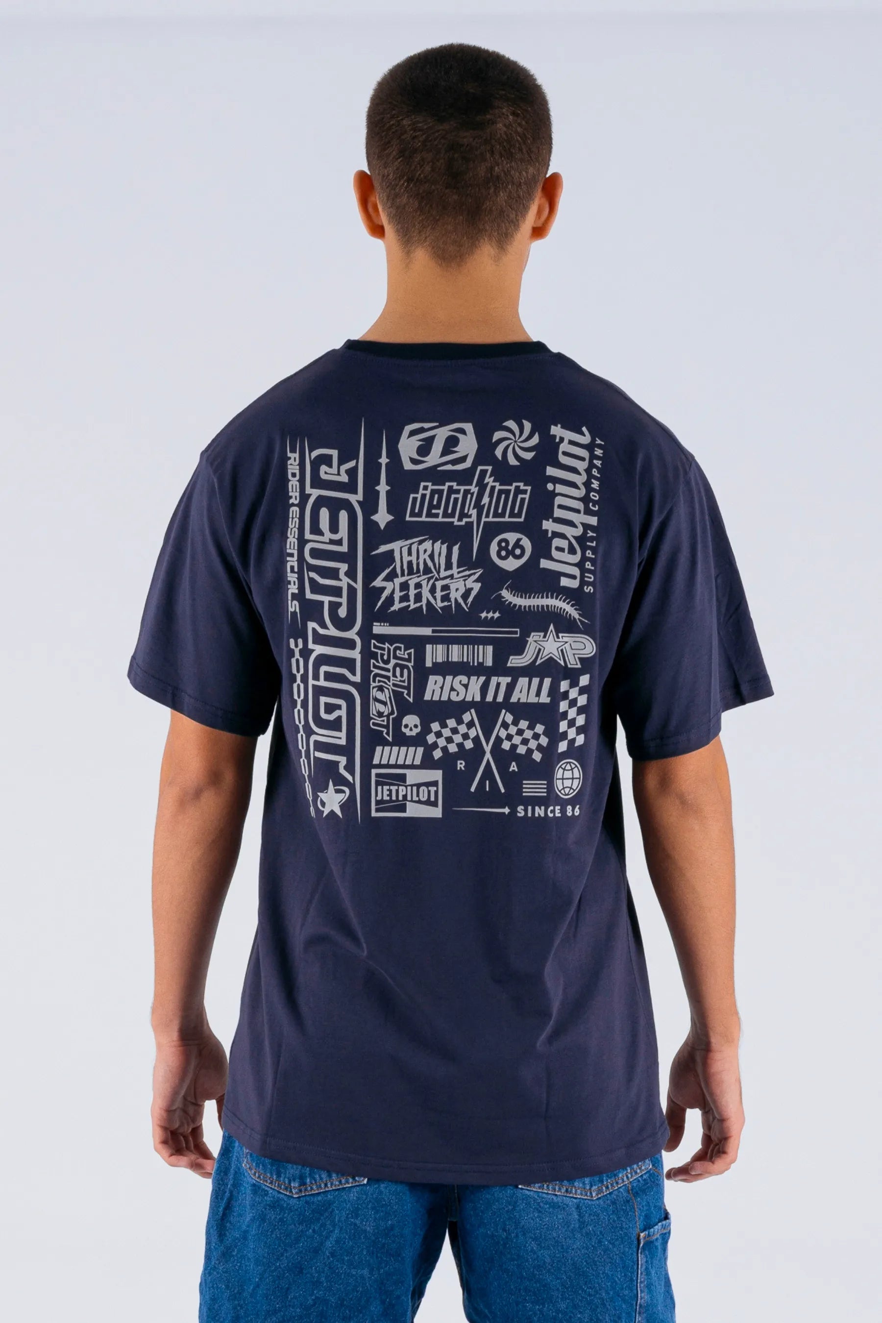 back view of a person wearing a dark blue tee with Jetpilot logos on a white background — view 2 (3)
