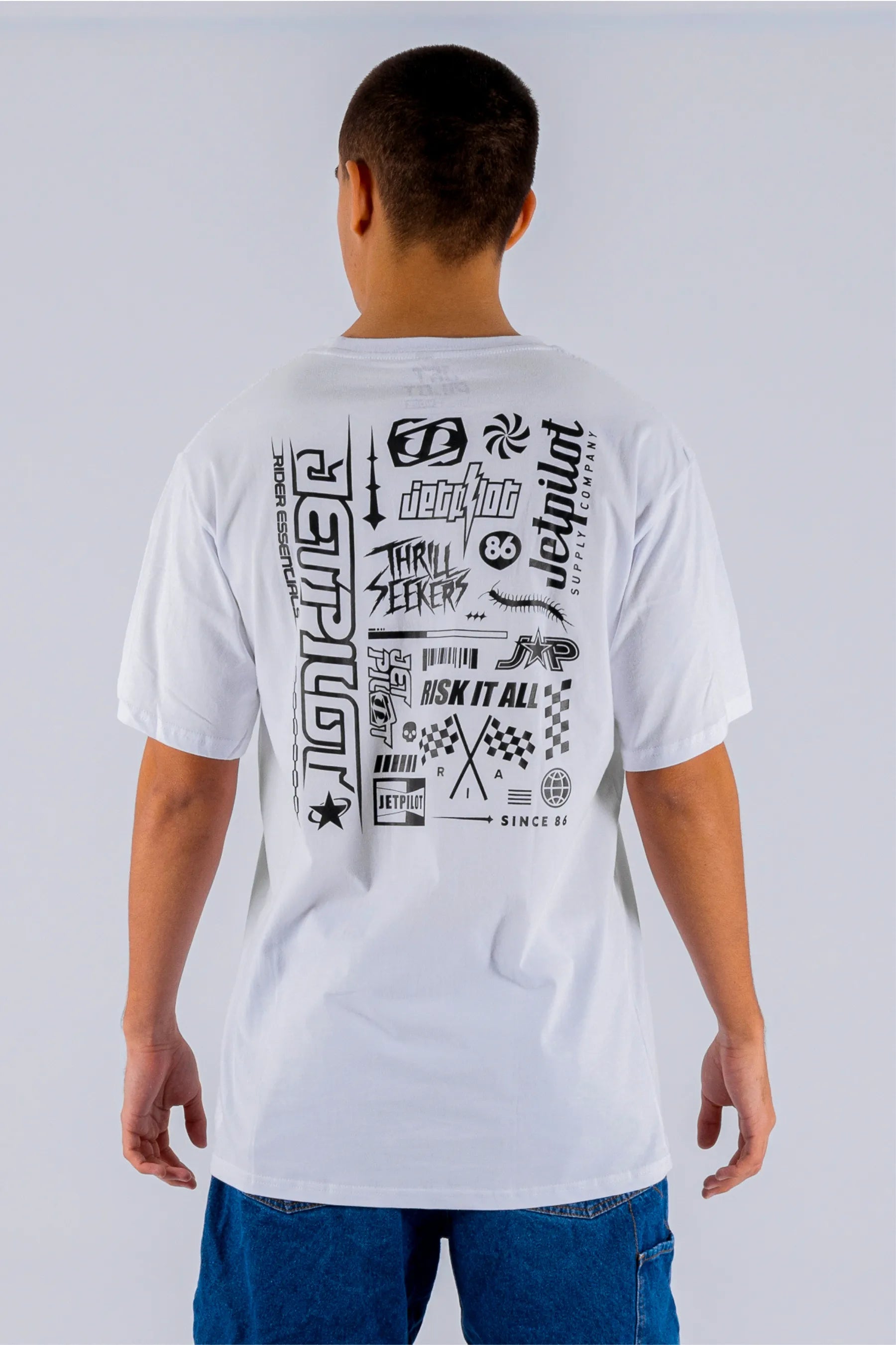 Back view of a person wearing a white tee with Jetpilot logos on a white background — view 1 (3)