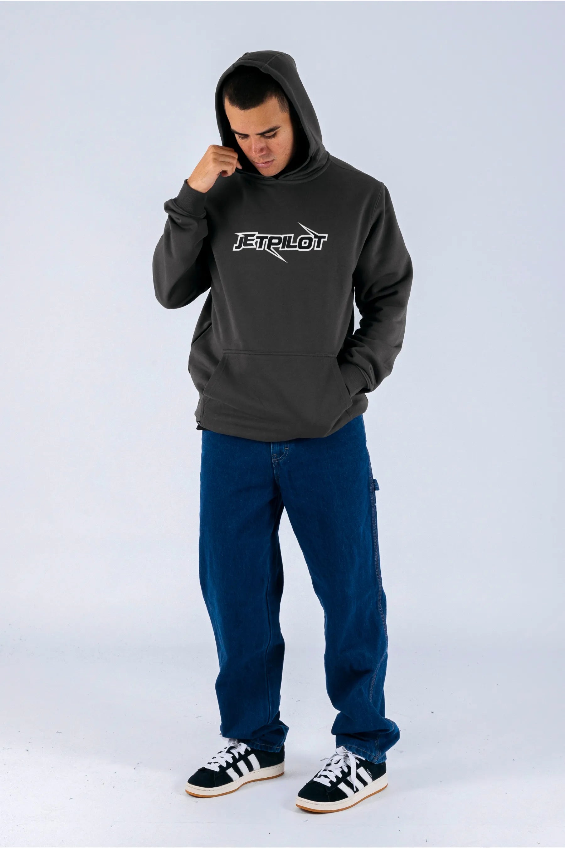 a person wearing a charcoal pullover with a Jetpilot logo, blue shorts and a black/white shoes — view 5 (6)