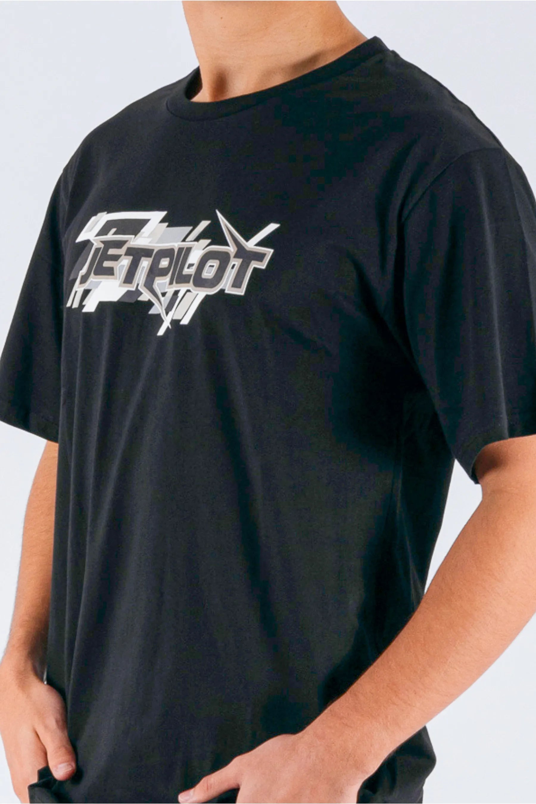 close up of a person wearing a black tee with a Jetpilot logo on a white background — view 5 (6)