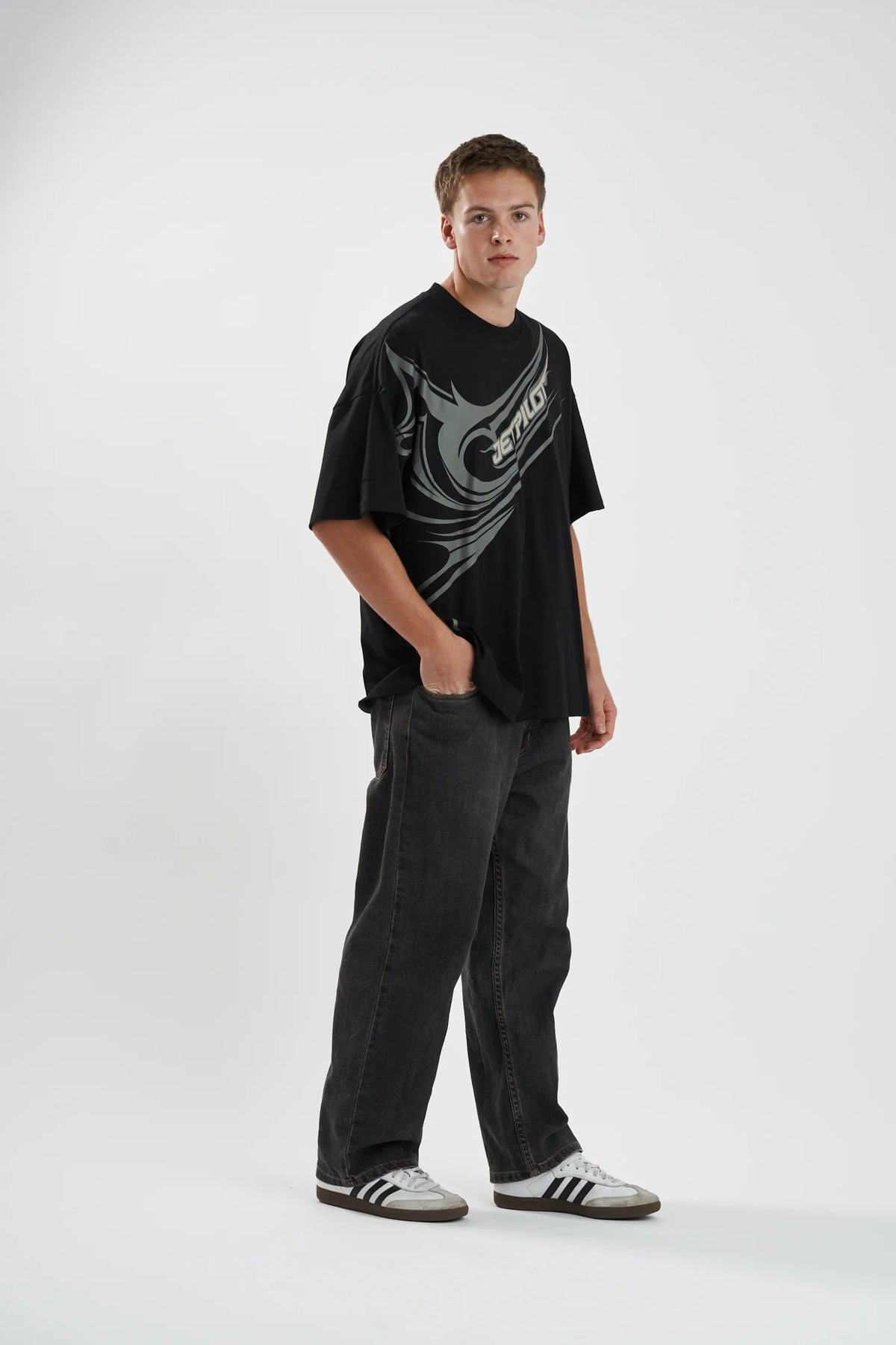 The black Sinister Tee worn with dark jeans, hand in pocket