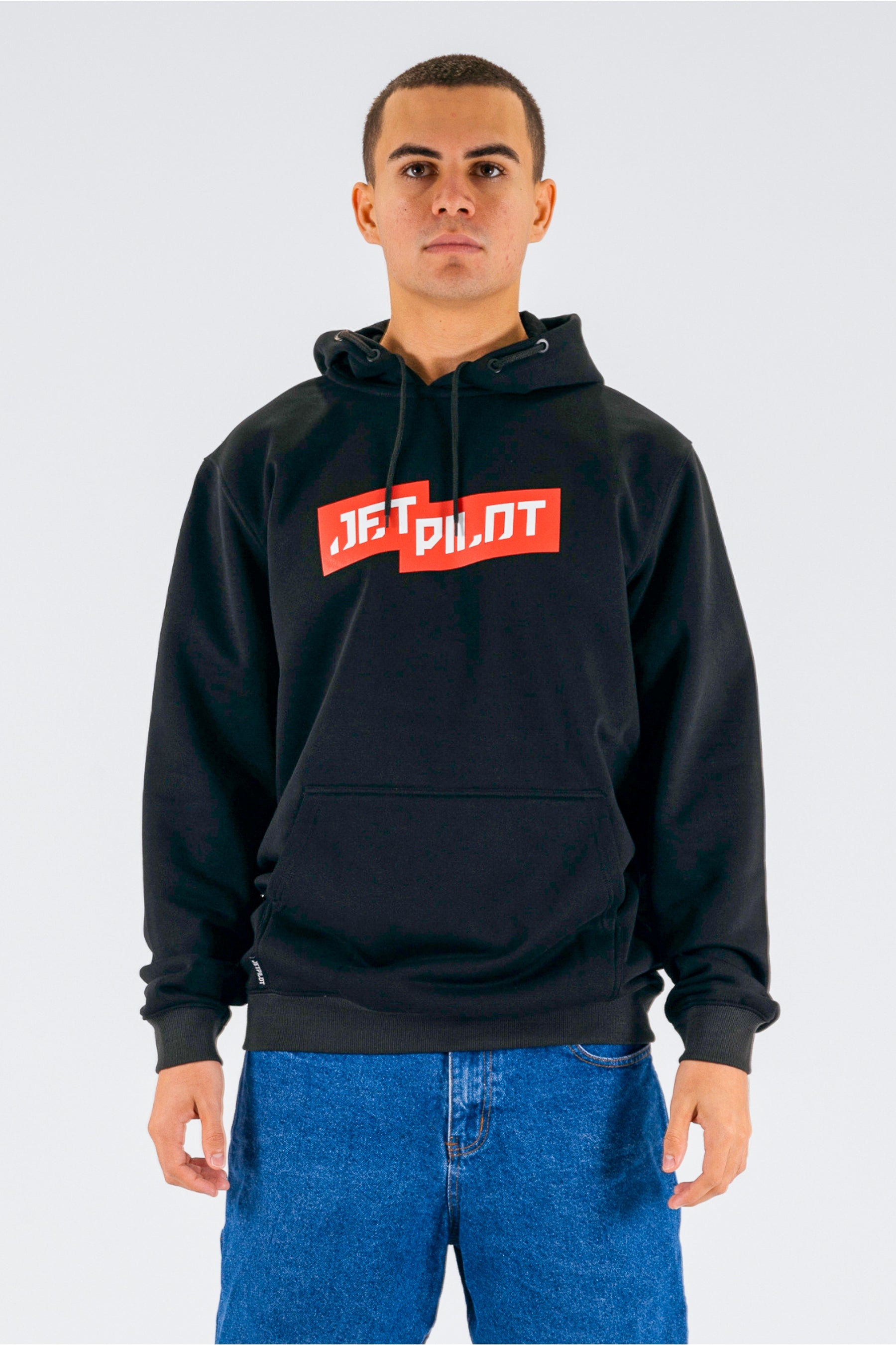 Front view of a person wearing a black pullover with a red Jetpilot logo on a white background — view 1 (3)