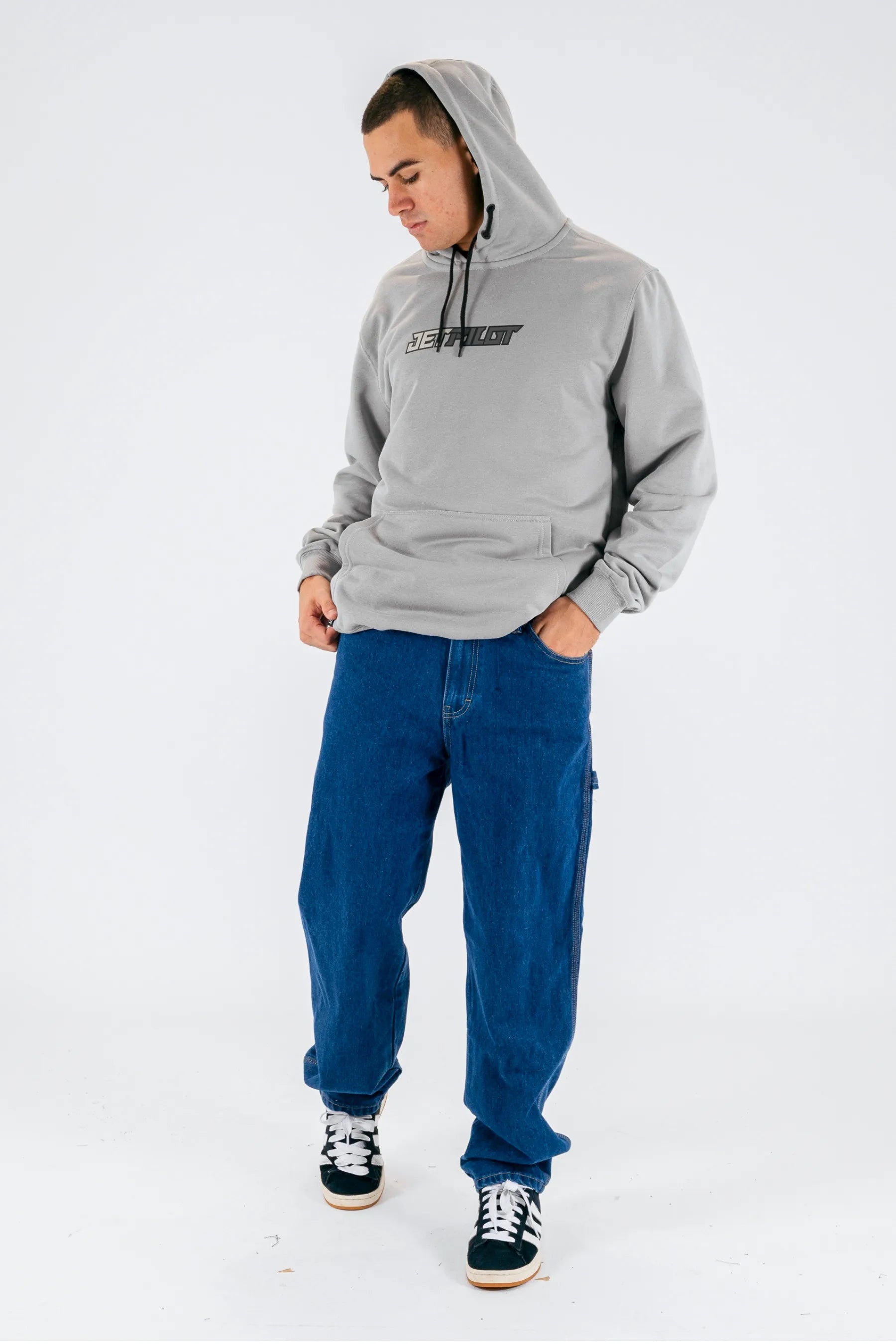 a person wearing a grey pullover with a Jetpilot logo, blue shorts and a black/white shoes on a white background — view 3 (3)