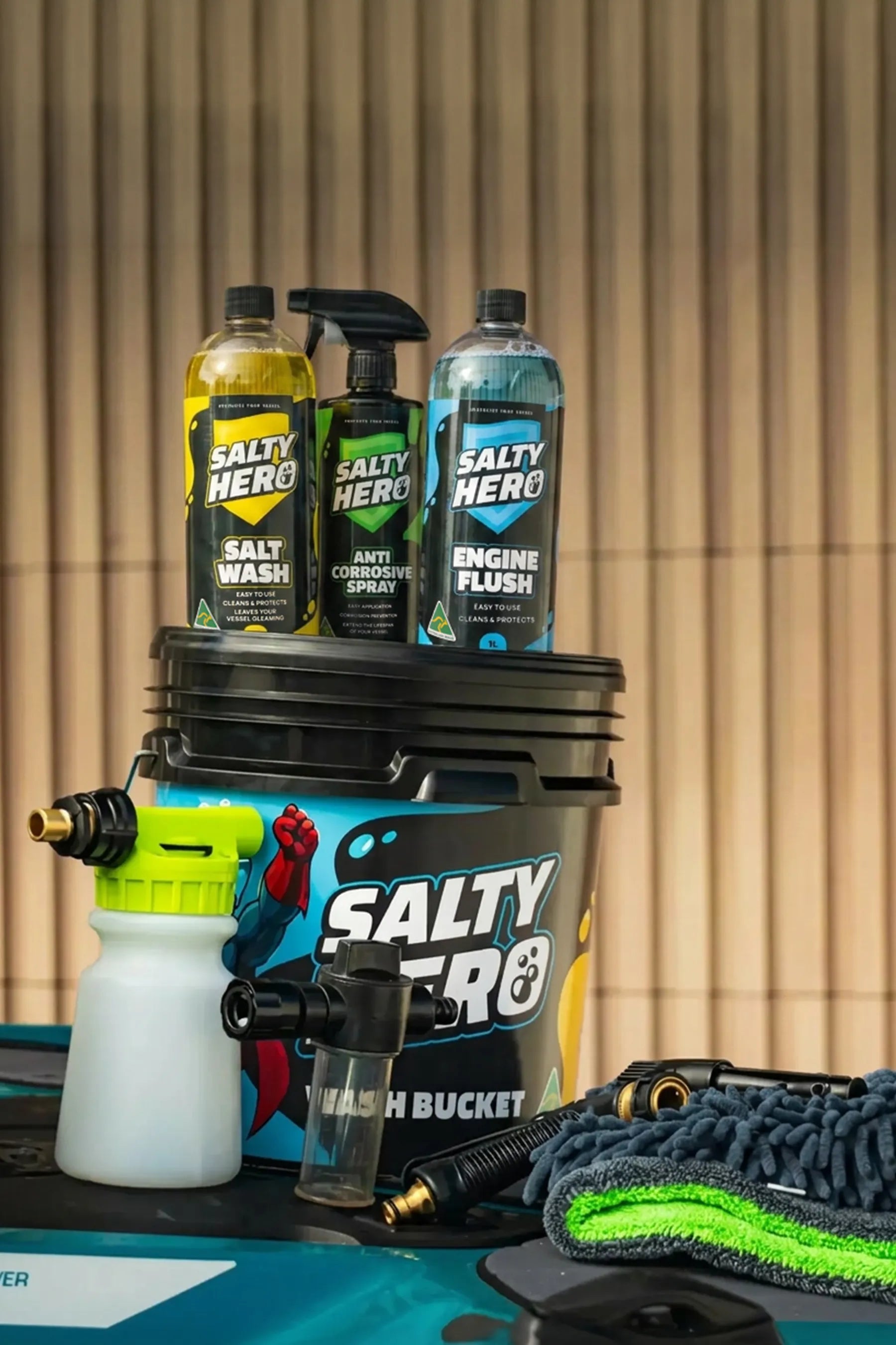 Salty Hero Boat and PWC Wash Care Kit products including a bucket, bottles, and a spray gun on a jetski hull.
