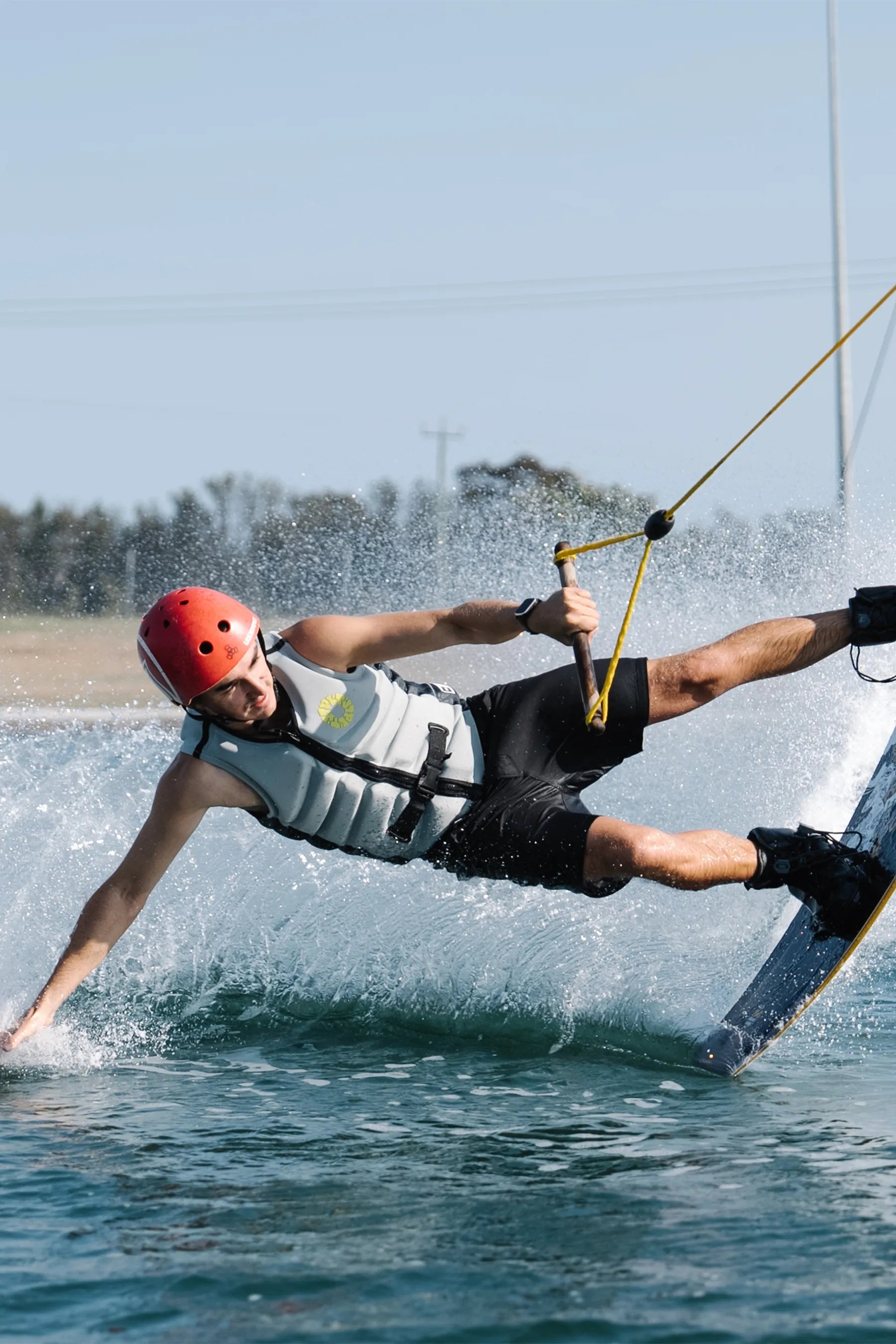 Person wakeboarding on a body of water with a clear sky