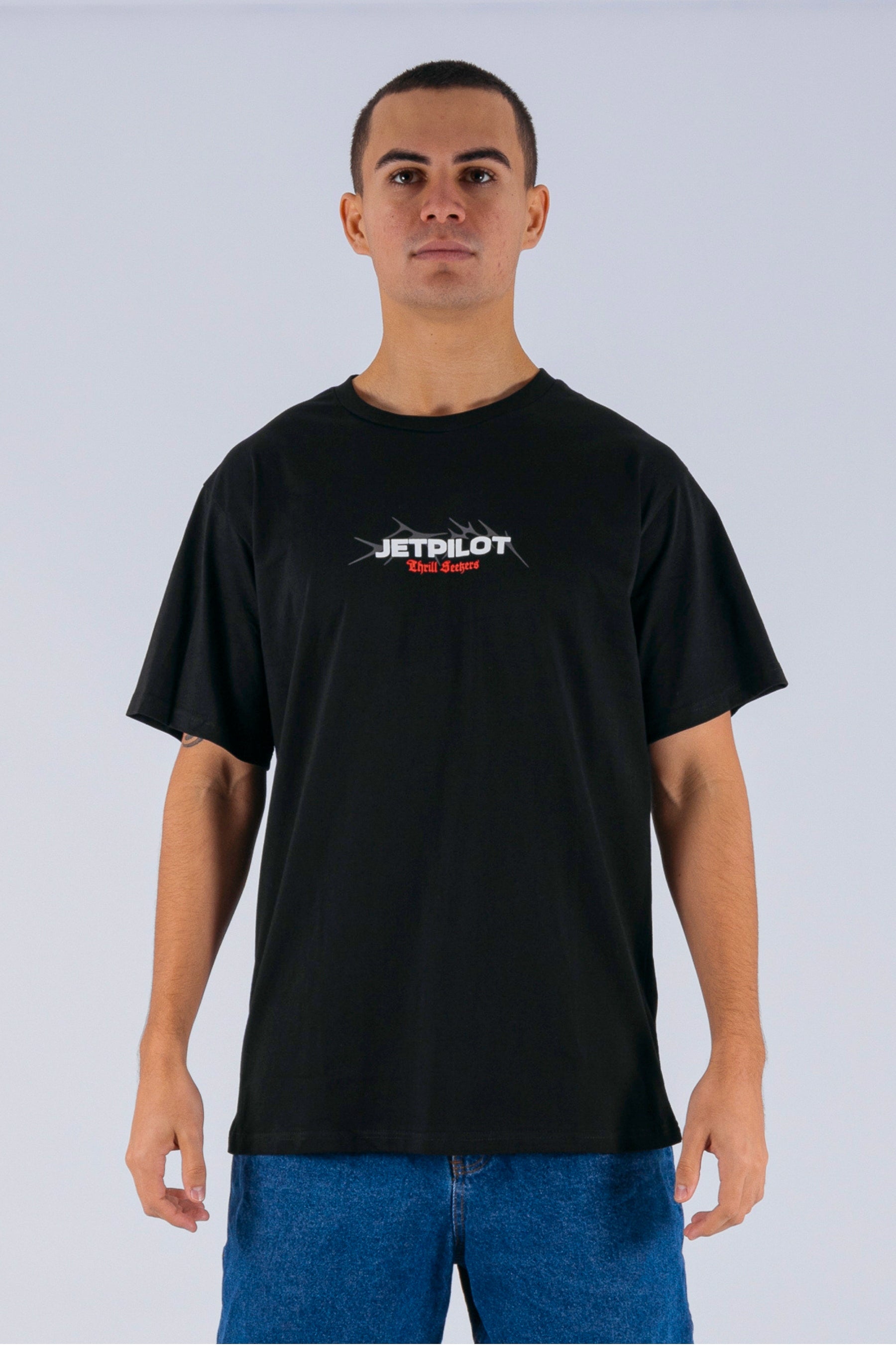 Front view of a person wearing a black tee with a white Jetpilot logo on a white background — view 1 (3)