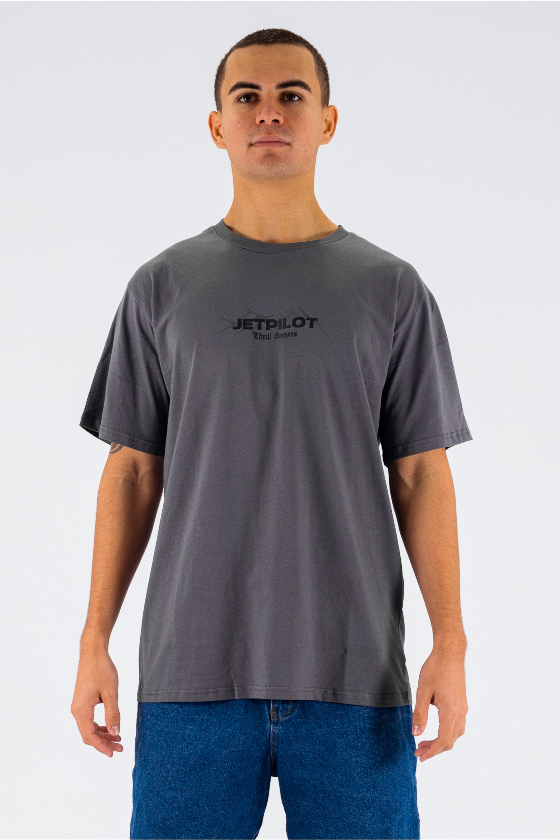 Front view of a person wearing a charcoal tee with a black Jetpilot logo on a white background — view 1 (3)