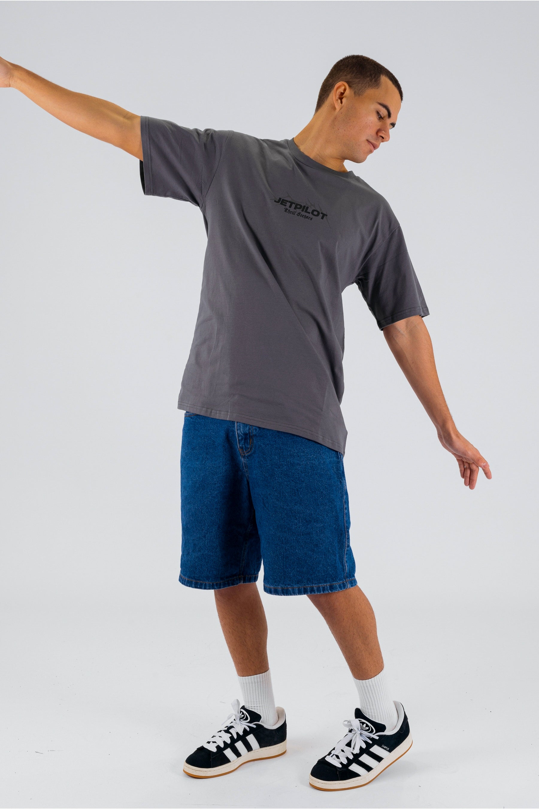 Angled view of a person wearing a charcoal tee with a black Jetpilot logo on a white background — view 3 (3)