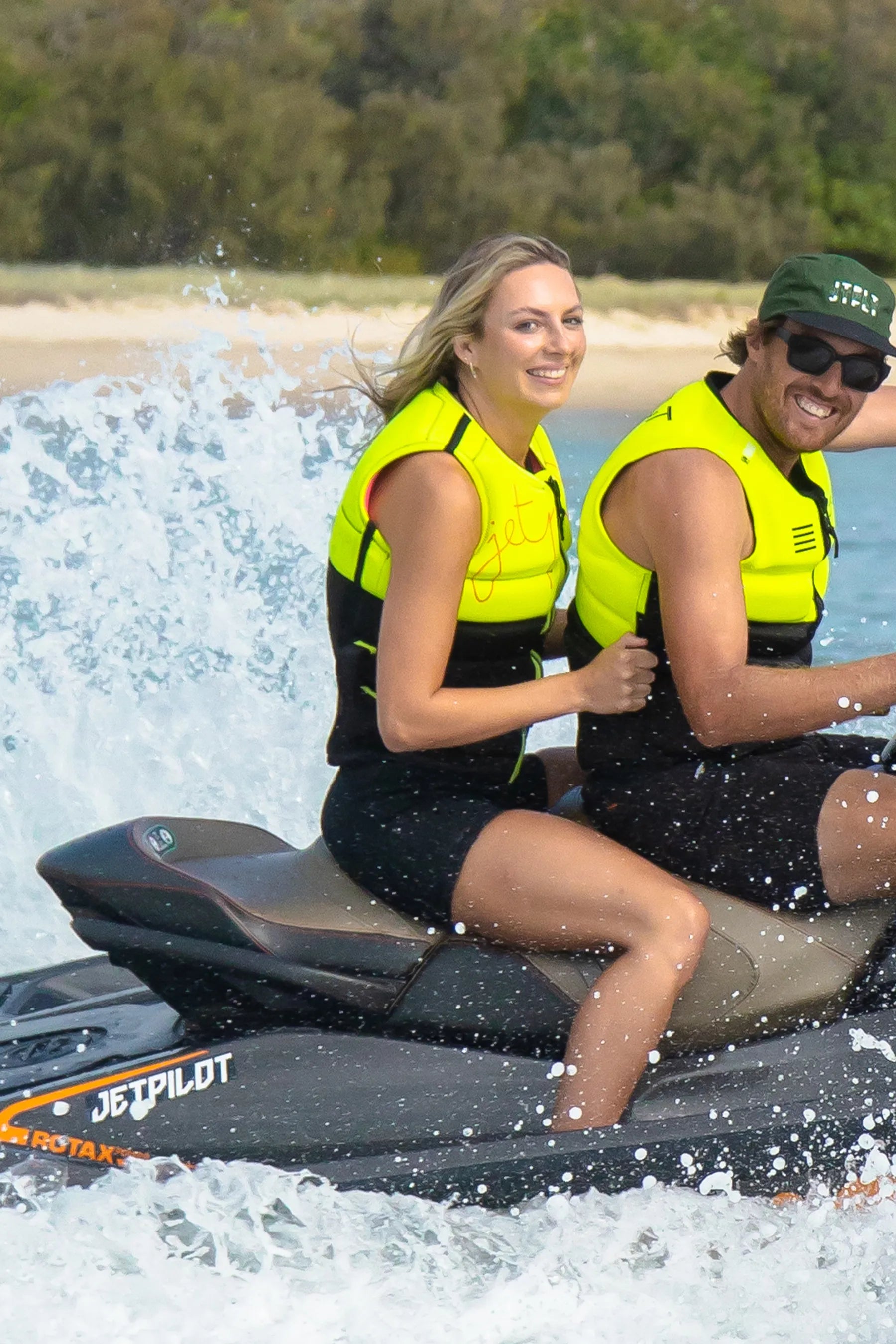 Two people on a Jetpilot watercraft with a scenic background