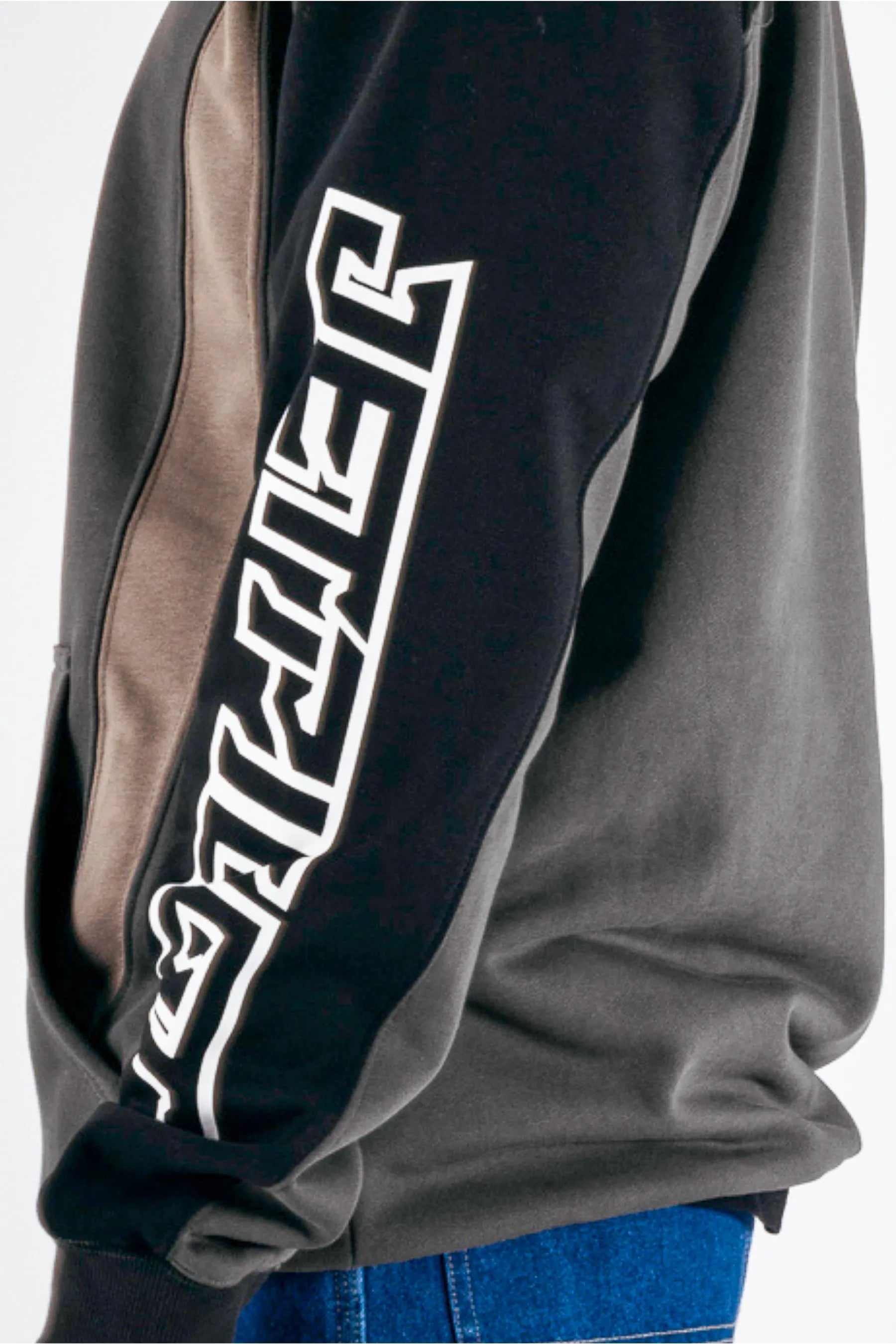 close up of the sleeve of person wear a black pullover with a white Jetpilot logo on a white background — view 4 (3)