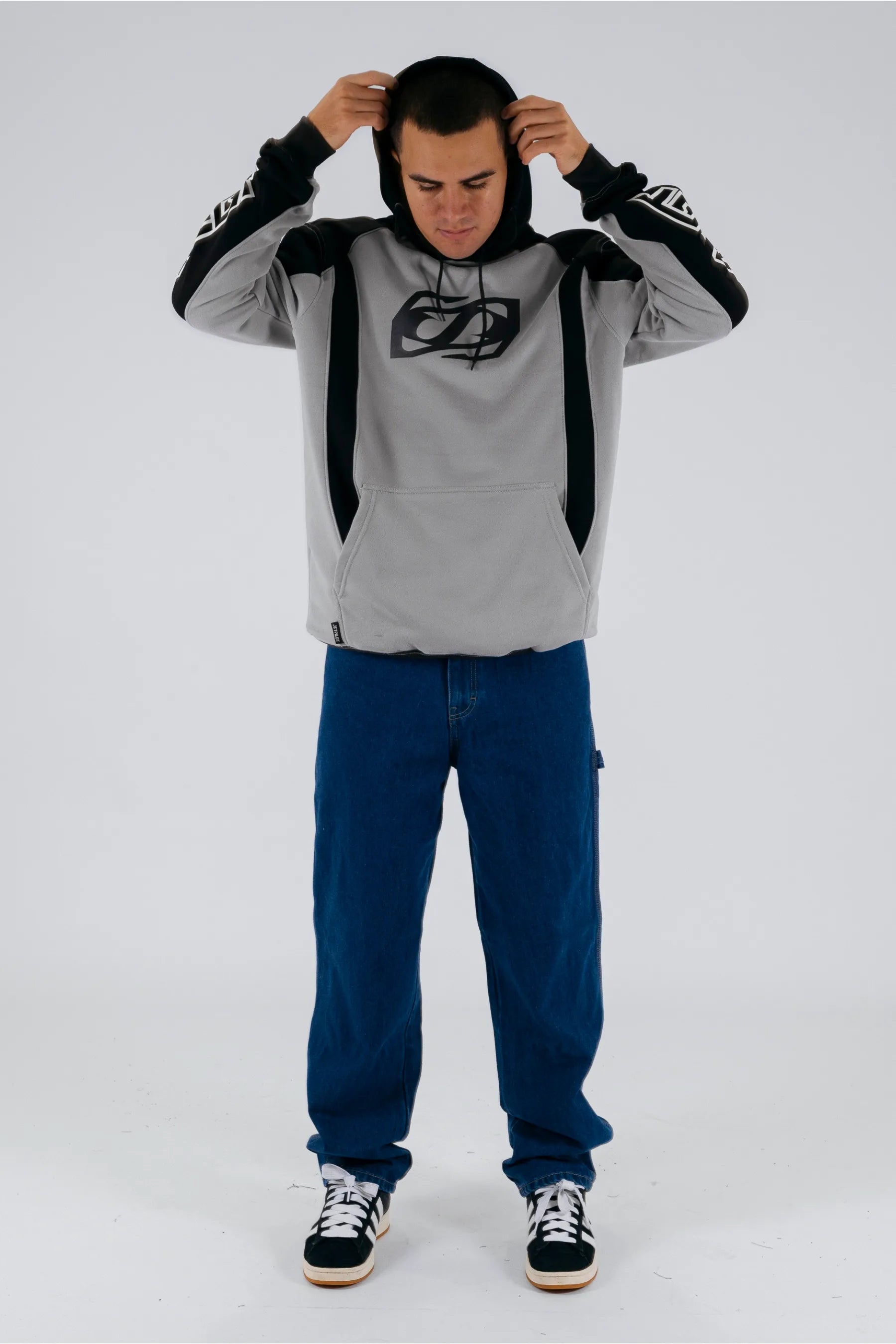 a person wearing a grey/black pullover with a Jetpilot logo, blue shorts and a black/white shoes — view 3 (3)
