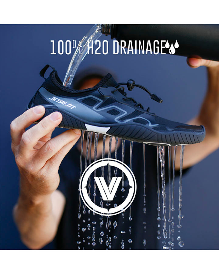 Black athletic shoe being held under a shower with water draining out, brand logo visible.