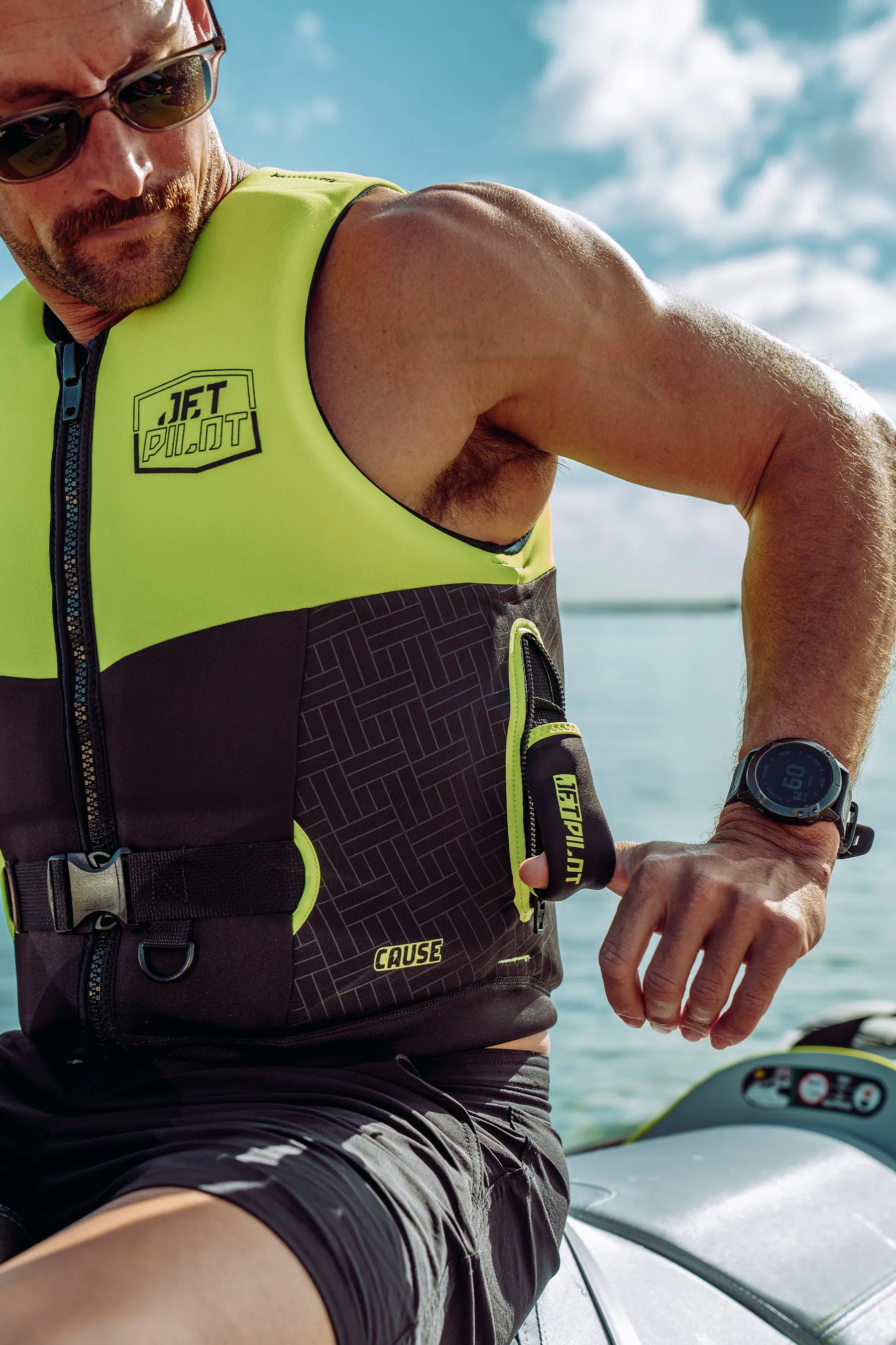 Man wearing a high-visibility life jacket on a boat with water and sky in the background