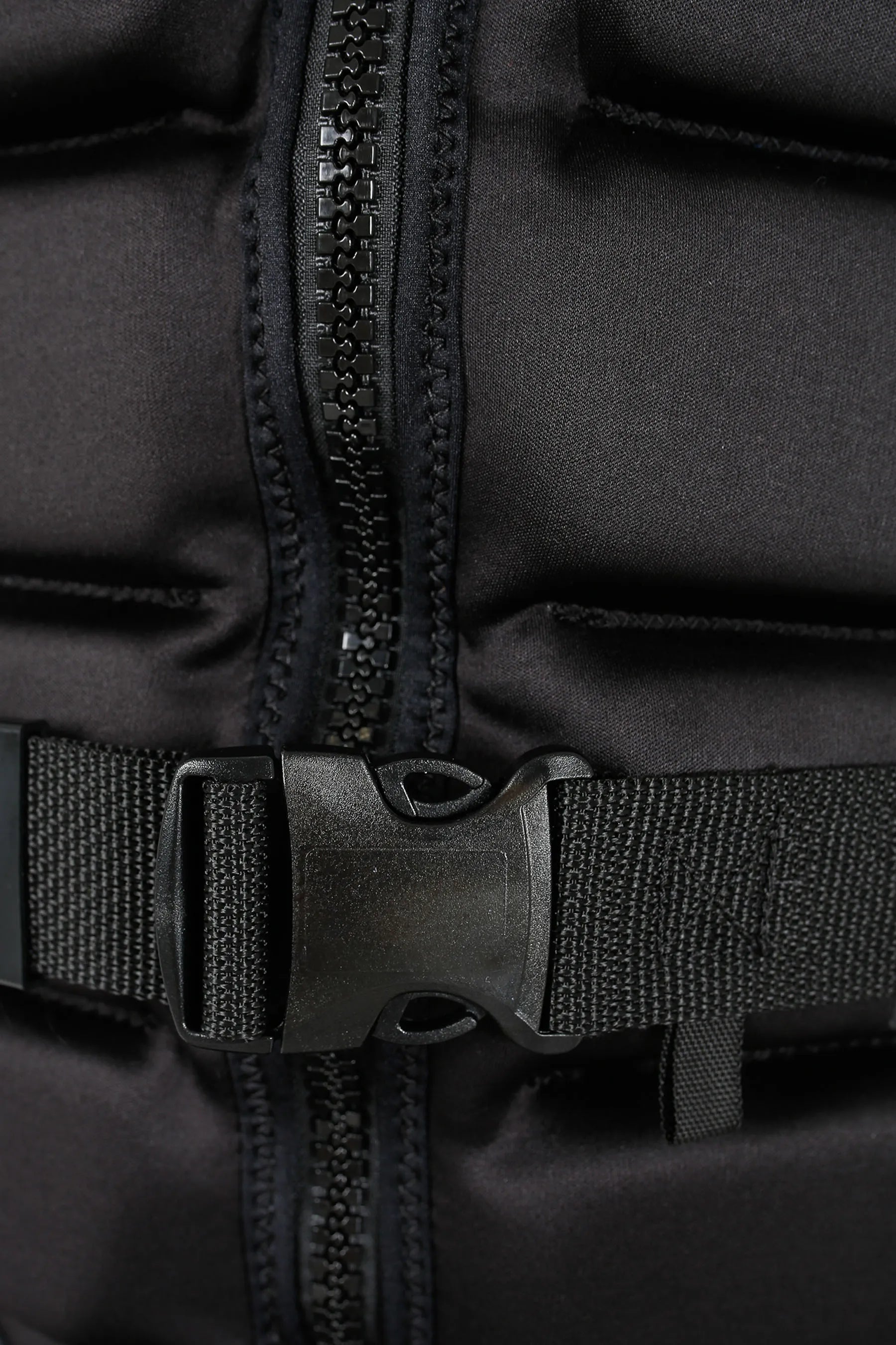 Close-up of a black life jacket with zipper and buckle details.