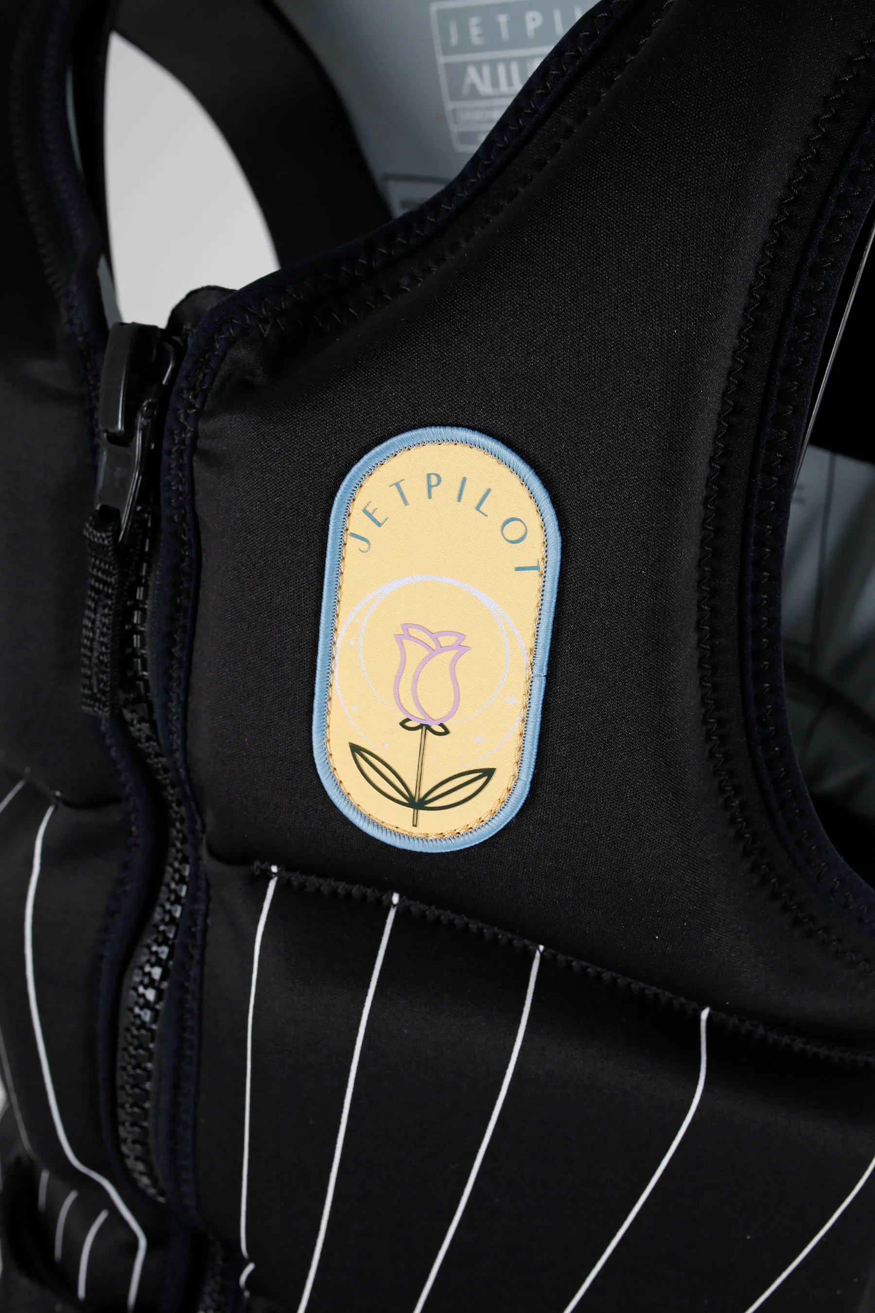 Jetpilot Allure Ladies Life Jacket - Black with Beige patch of flower and Jetpilot brand

