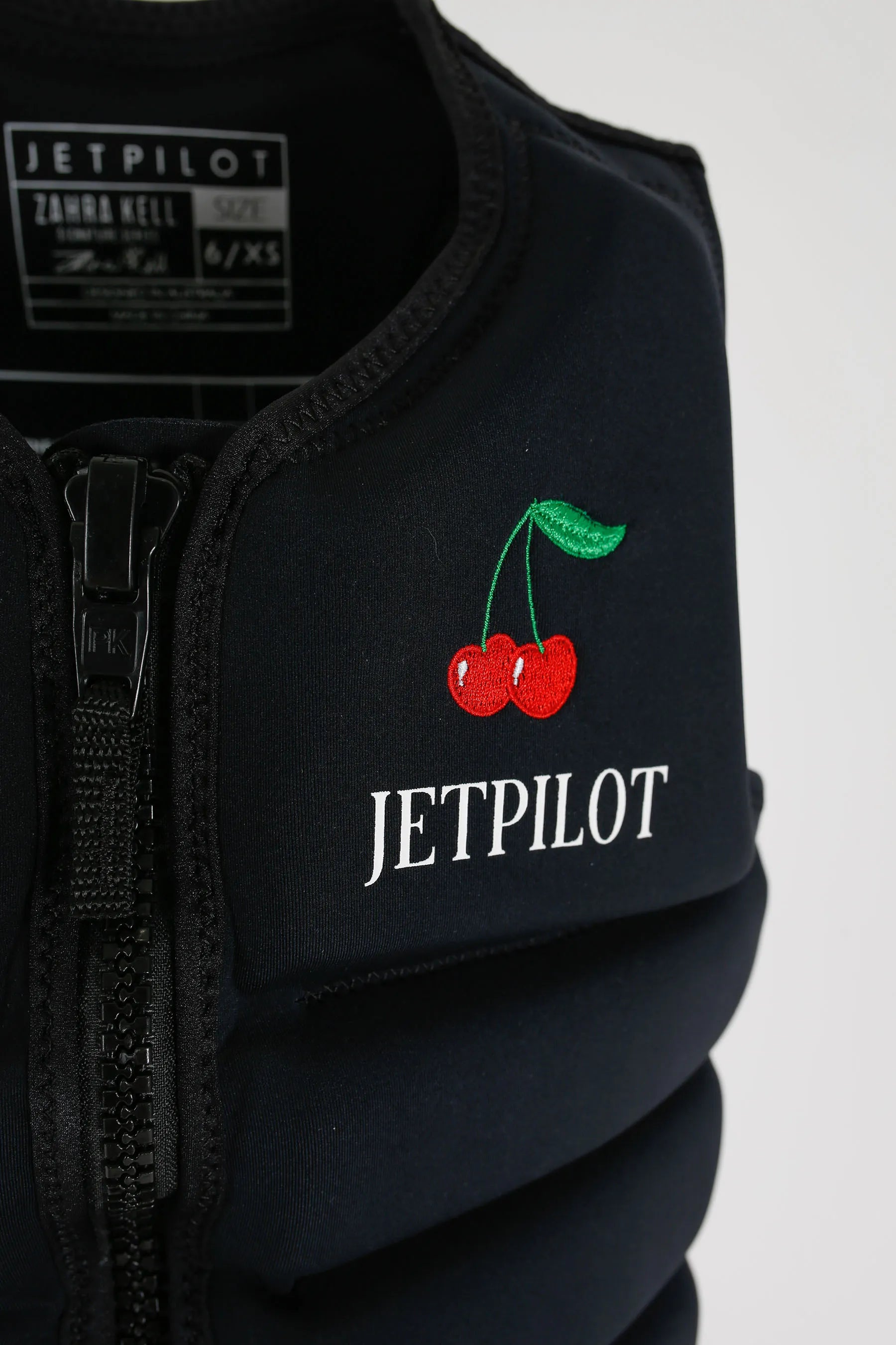 Jetpilot X1 Ladies Life Jacket - Zahra Kell Signature Series - Black with cherry design and 'Jetpilot' branding on a white background