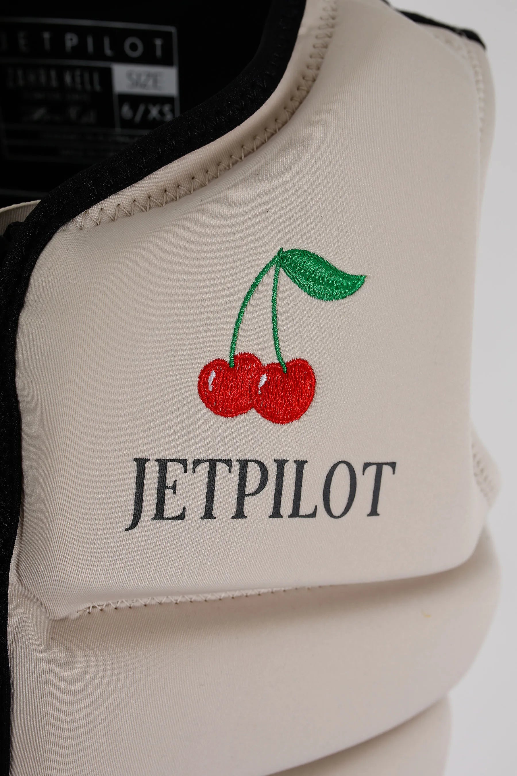 Jetpilot X1 Ladies Life Jacket - Zahra Kell Signature Series - Off White with embroidered cherries and 'JETPILOT' text on a white background