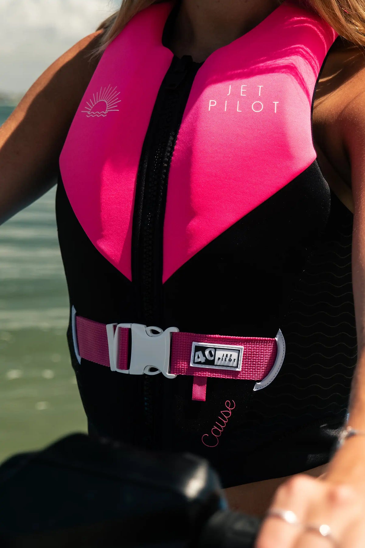 Close-up of a rider on a jet ski in the Pink Cause Ladies, showing the pink waist strap and 40 tab