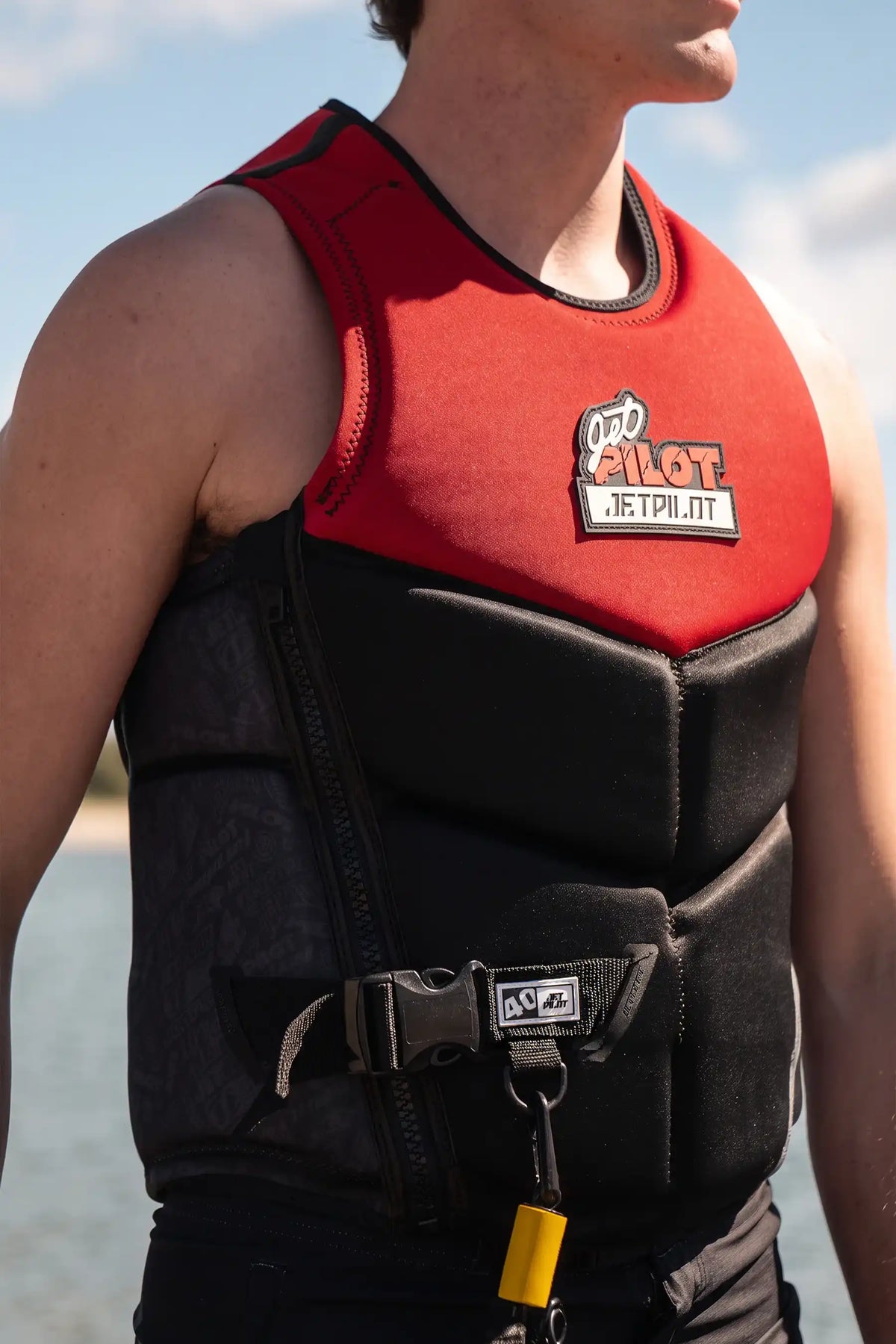 Model in the Red 40 Year Nighthawk with a yellow kill-switch lanyard clipped below the belt buckle and 40 tab
