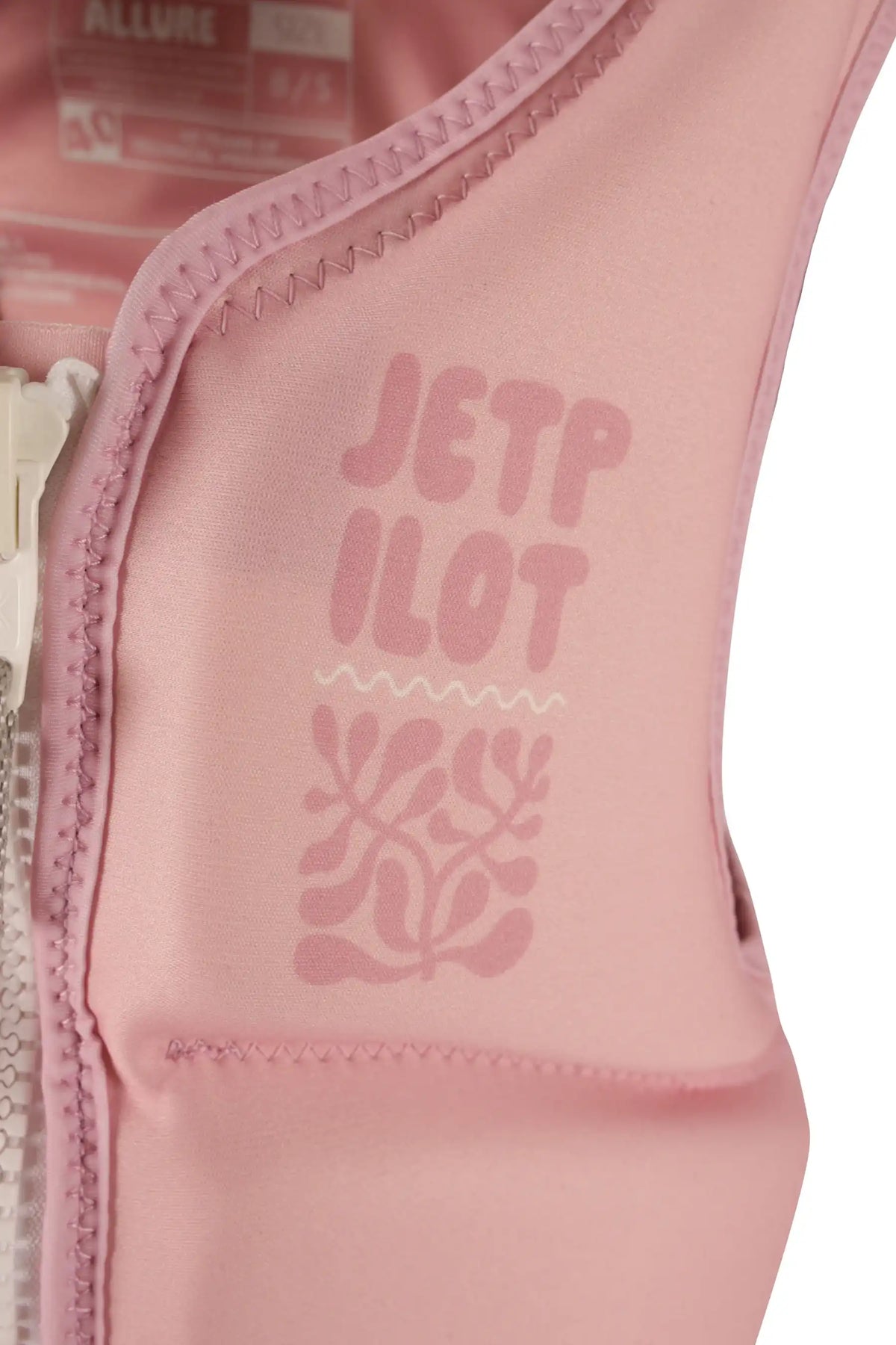 Close-up of the tonal stacked Jetpilot logo and leafy motif on the chest of the Pink Allure