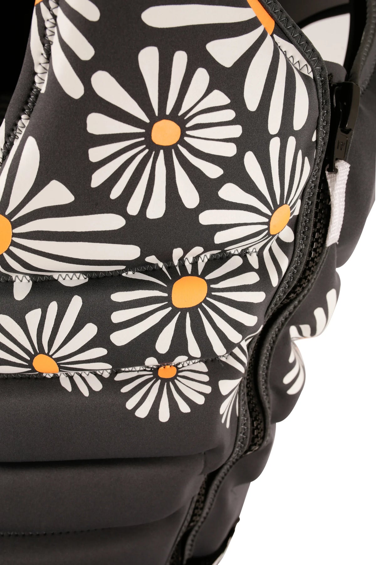 Close-up of the daisy print crossing the panel seams beside the zip on the Charcoal Isla