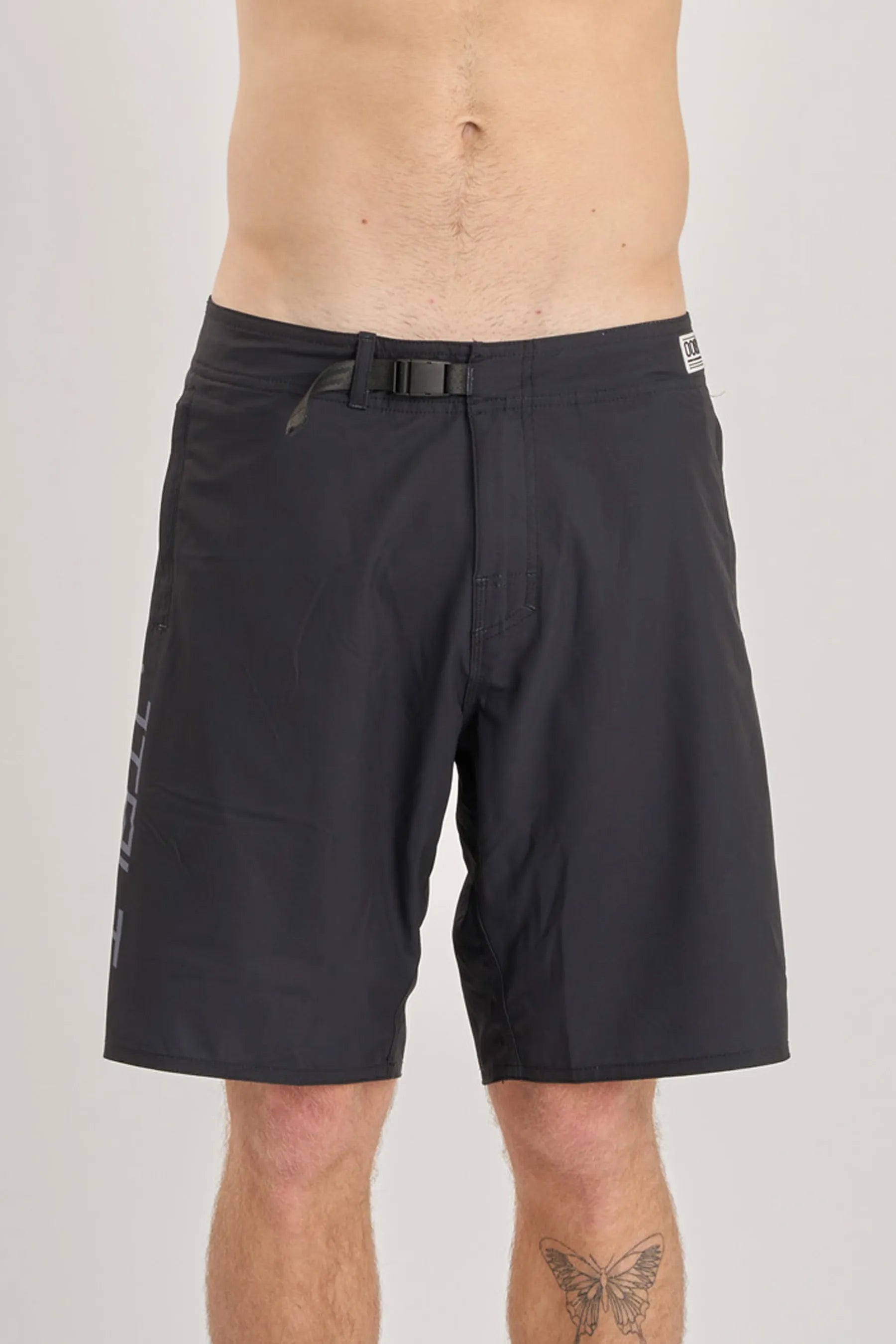 Black shorts worn by a person on a plain background