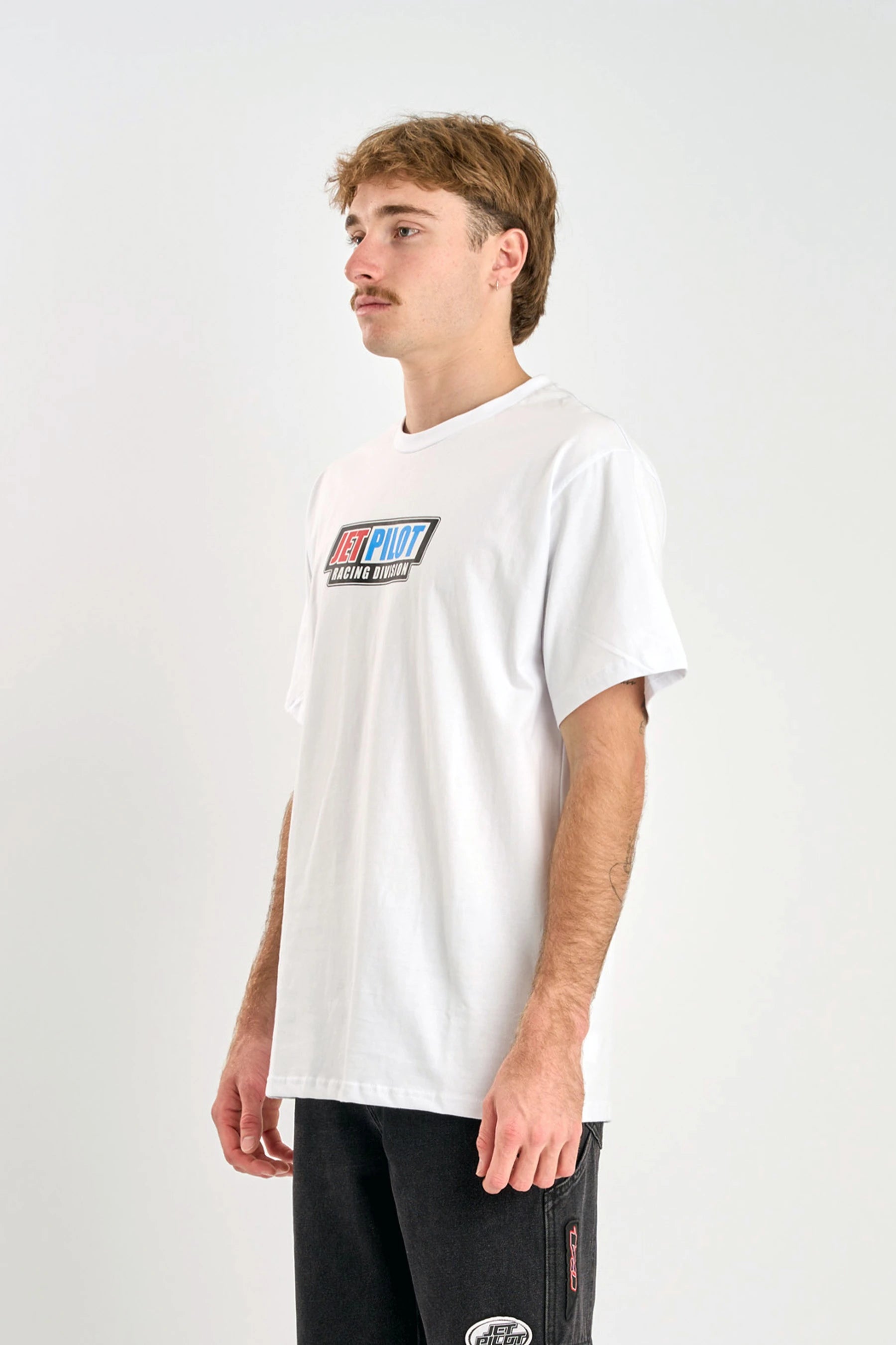 Person wearing a Jetpilot Pulse Streamliner Tee - White t-shirt with a colorful logo on a plain background — image 2