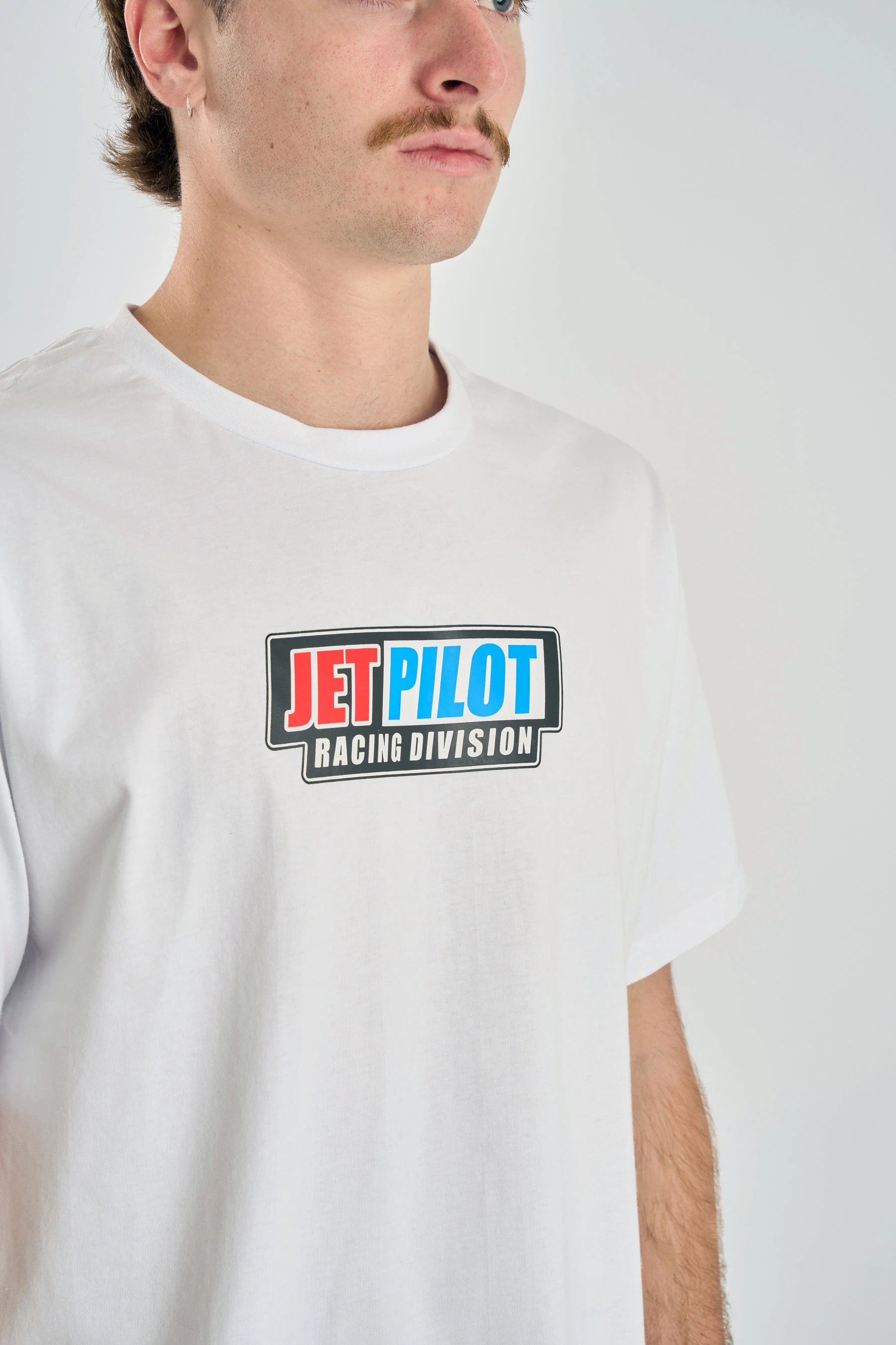 Person wearing a white t-shirt with a Jetpilot logo on a plain background — image 2