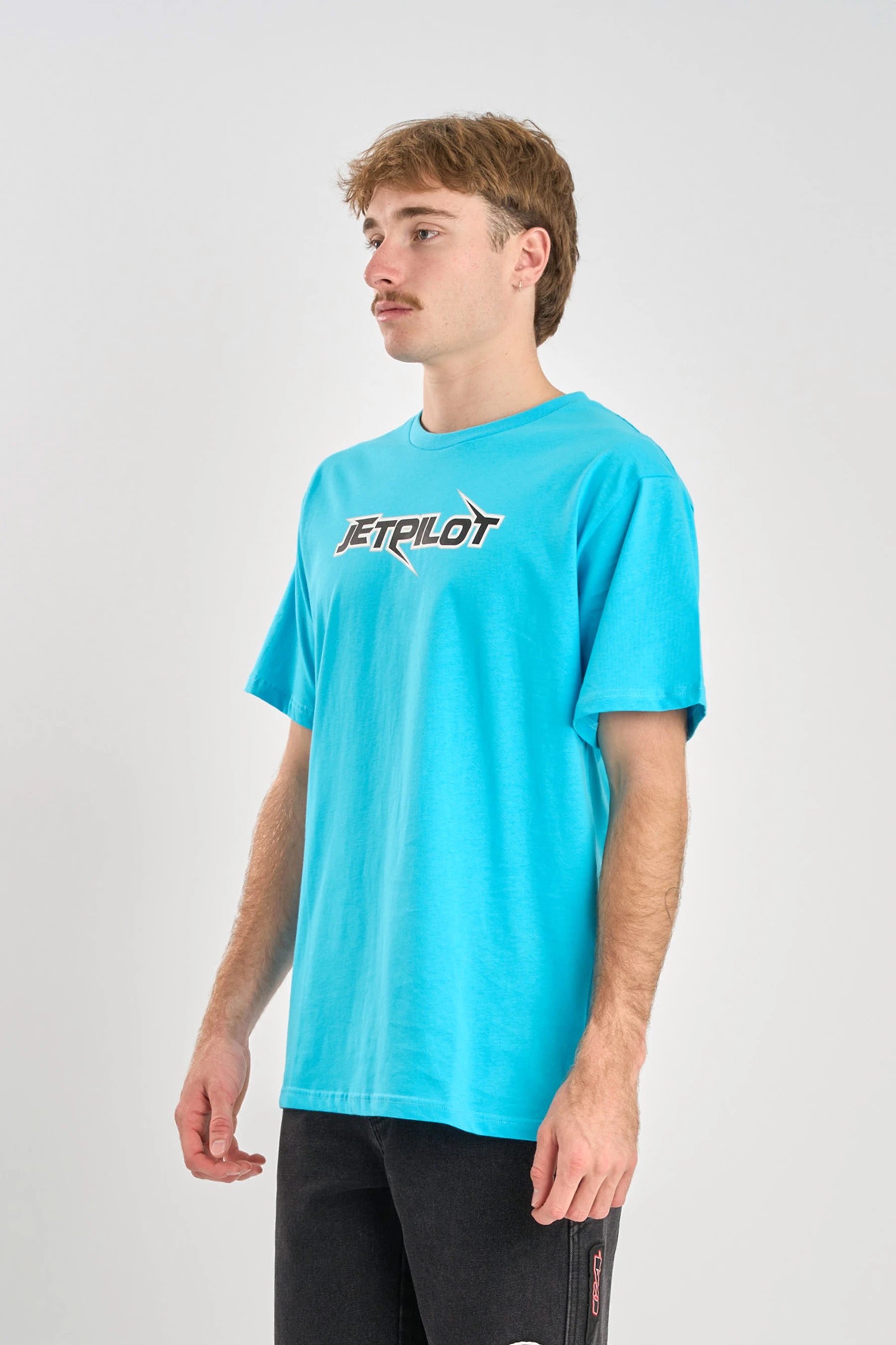 Person wearing a blue t-shirt with 'JETPILOT' logo on a white background — image 2