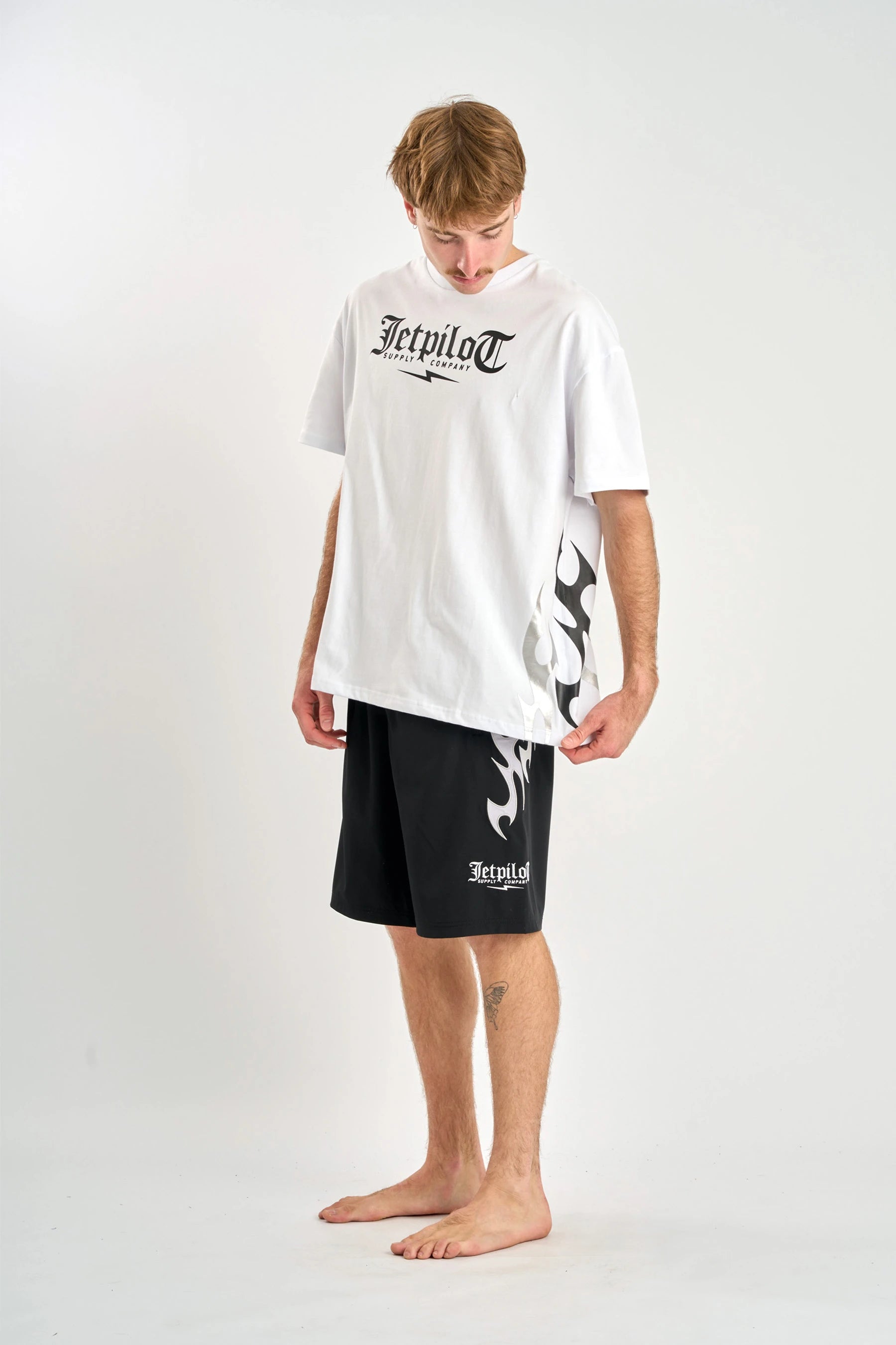 Person wearing a white t-shirt and black shorts with 'Jetpilot' branding on a white background — image 2